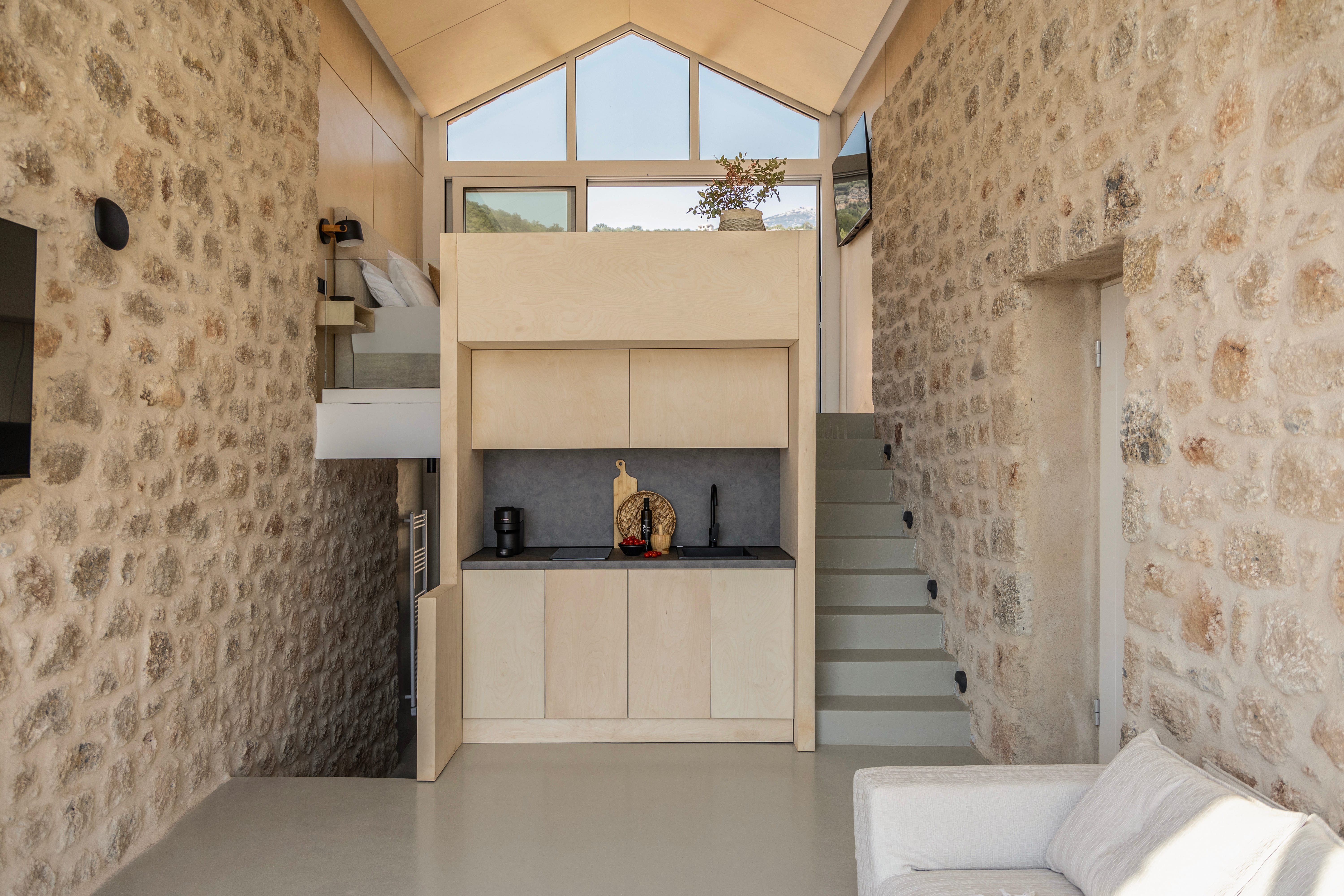 a room with a loft bed and stairs