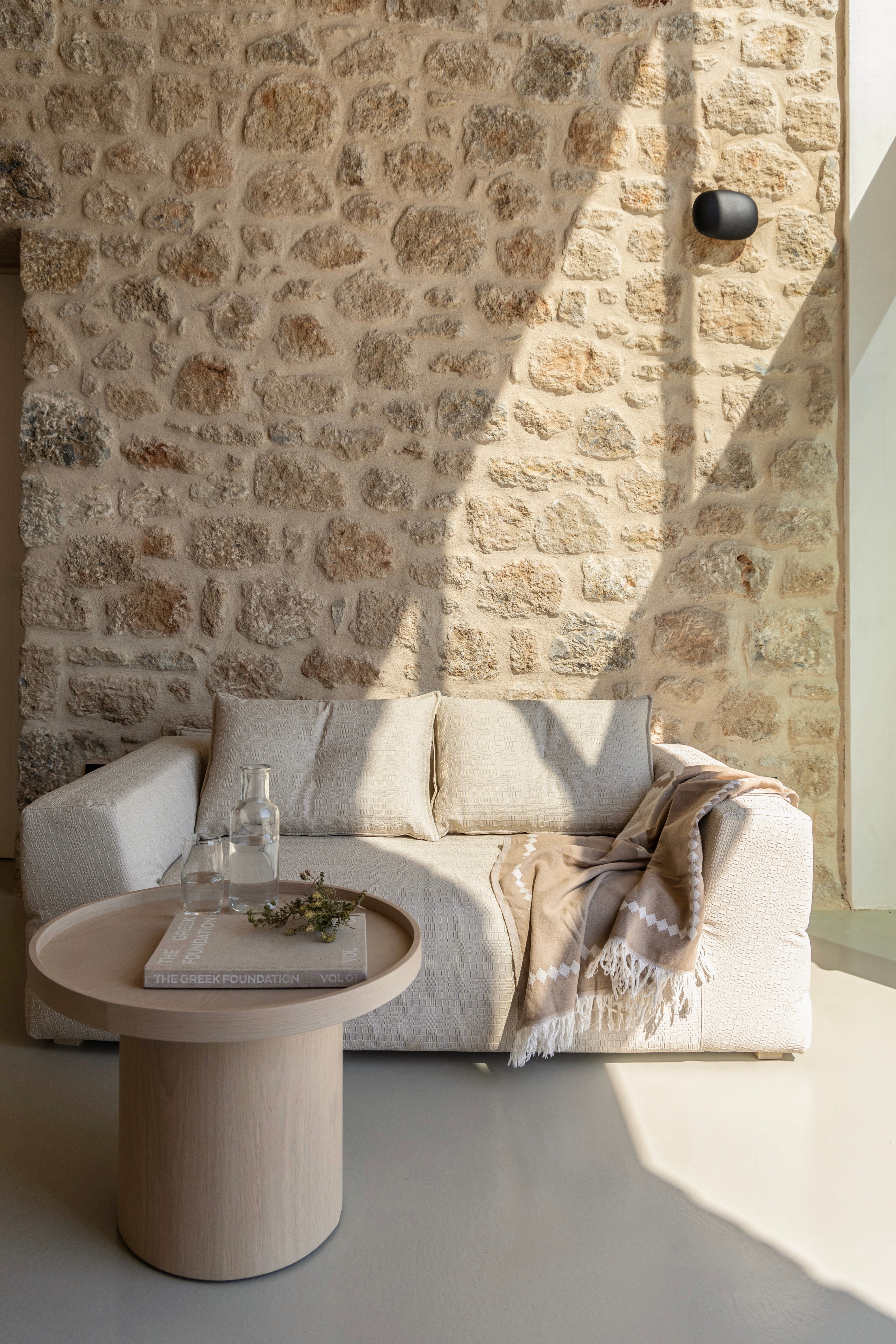 a couch and a table in front of a stone wall