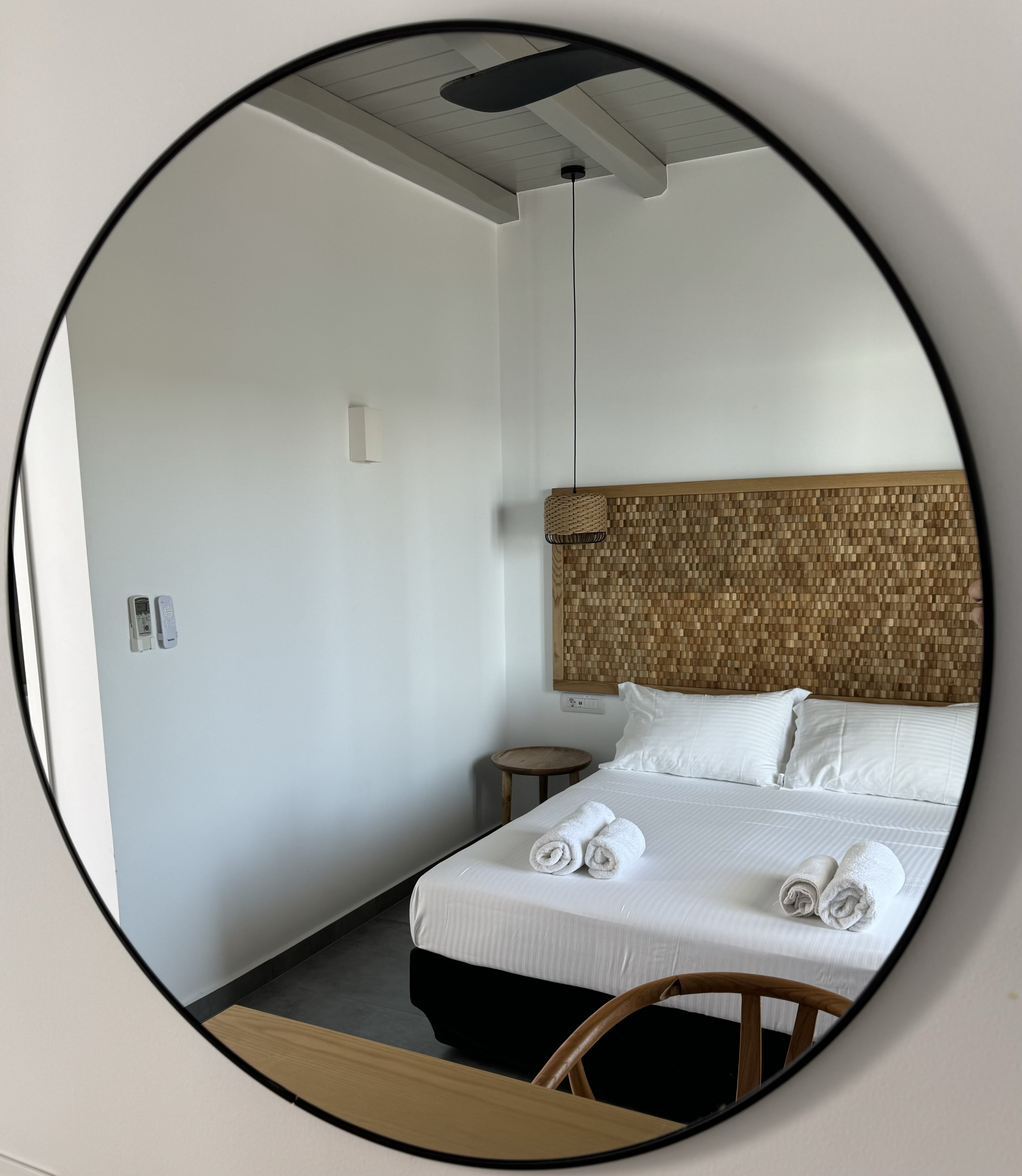 a mirror showing a bed and a chair