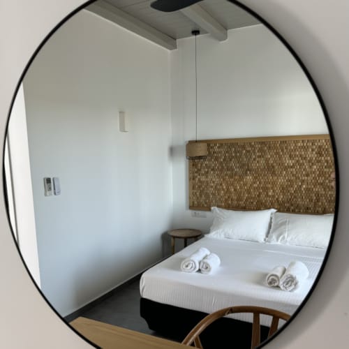a mirror showing a bed and a chair