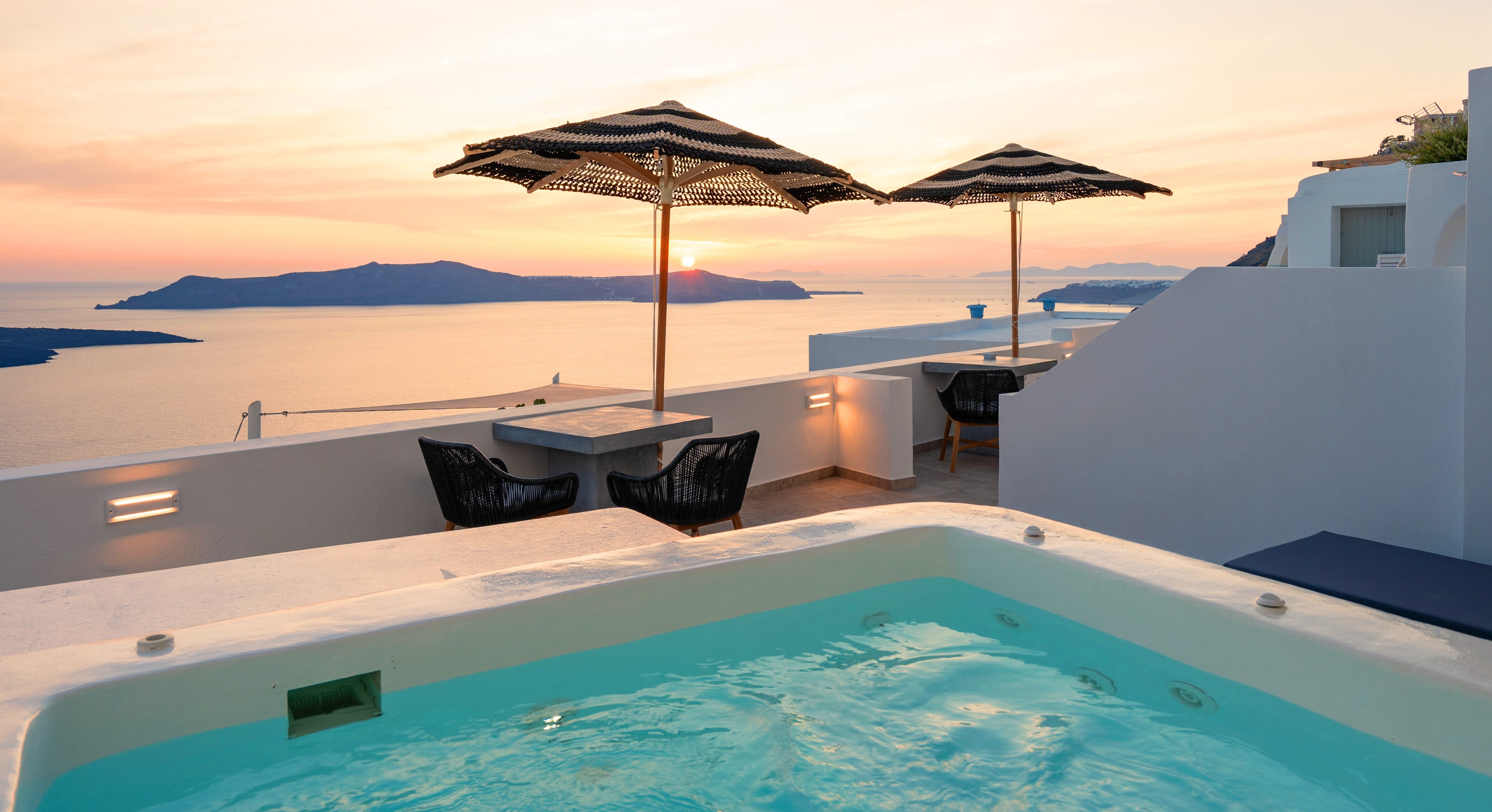 a pool with umbrellas and chairs by a beach