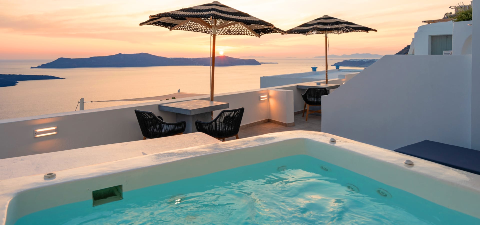 a pool with umbrellas and chairs by a beach