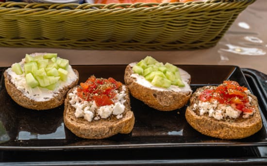 a group of muffins with different toppings on a black tray