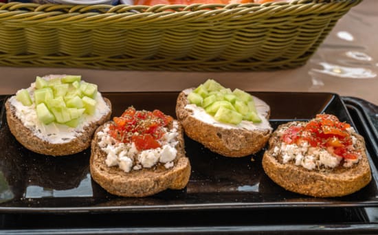 a group of muffins with different toppings on a black tray