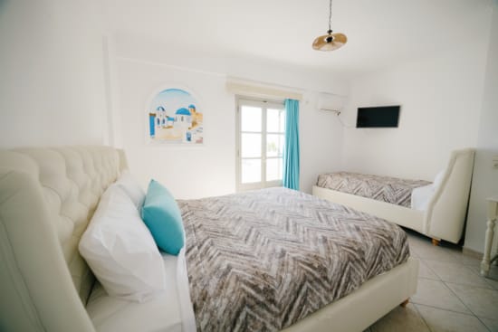 a room with white couches and a painting on the wall