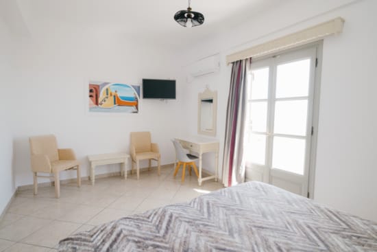 a bedroom with a bed and chairs