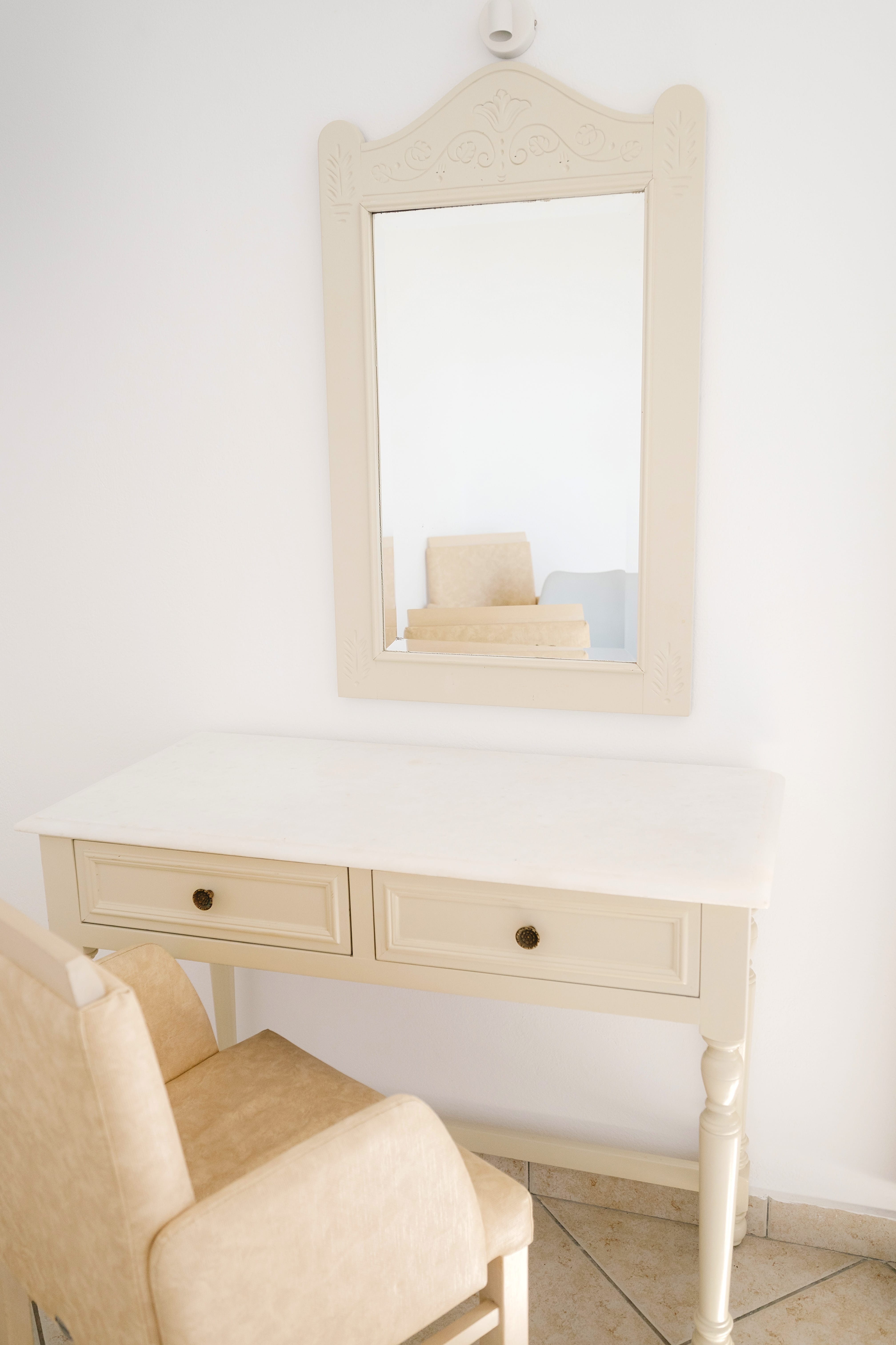 a white dresser with a mirror above it