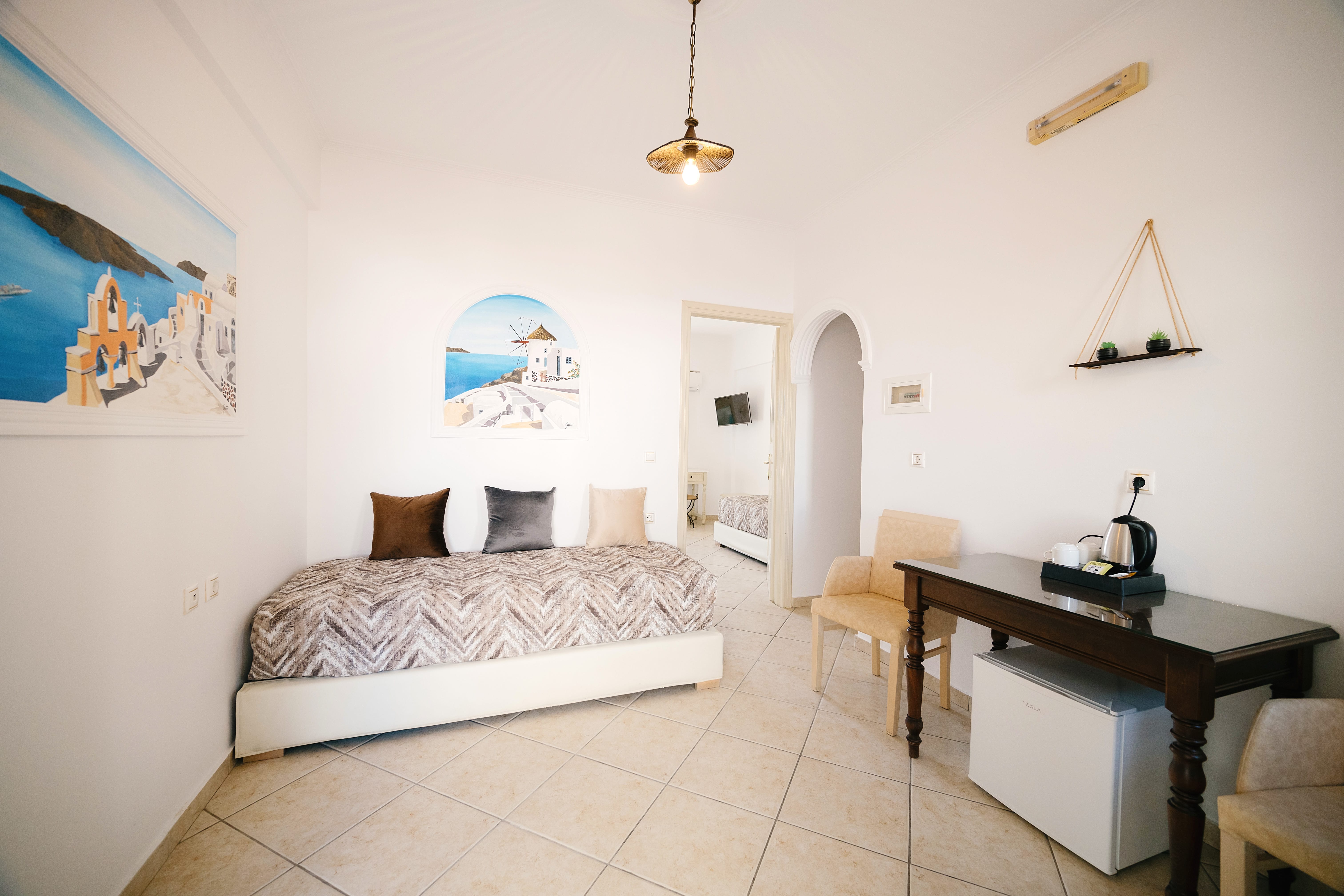 a bedroom with a bed desk and a painting on the wall