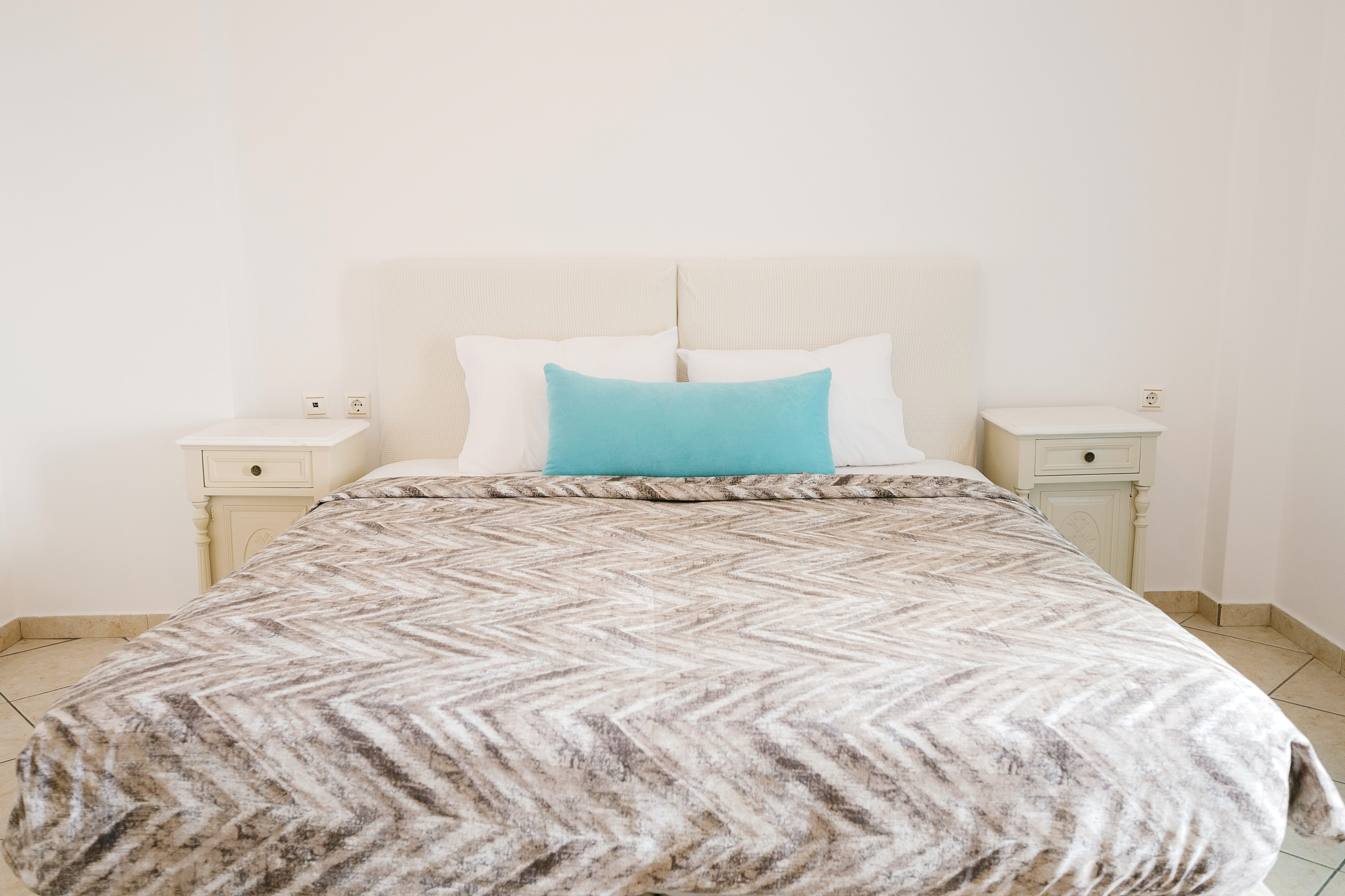 a bed with a white and blue comforter