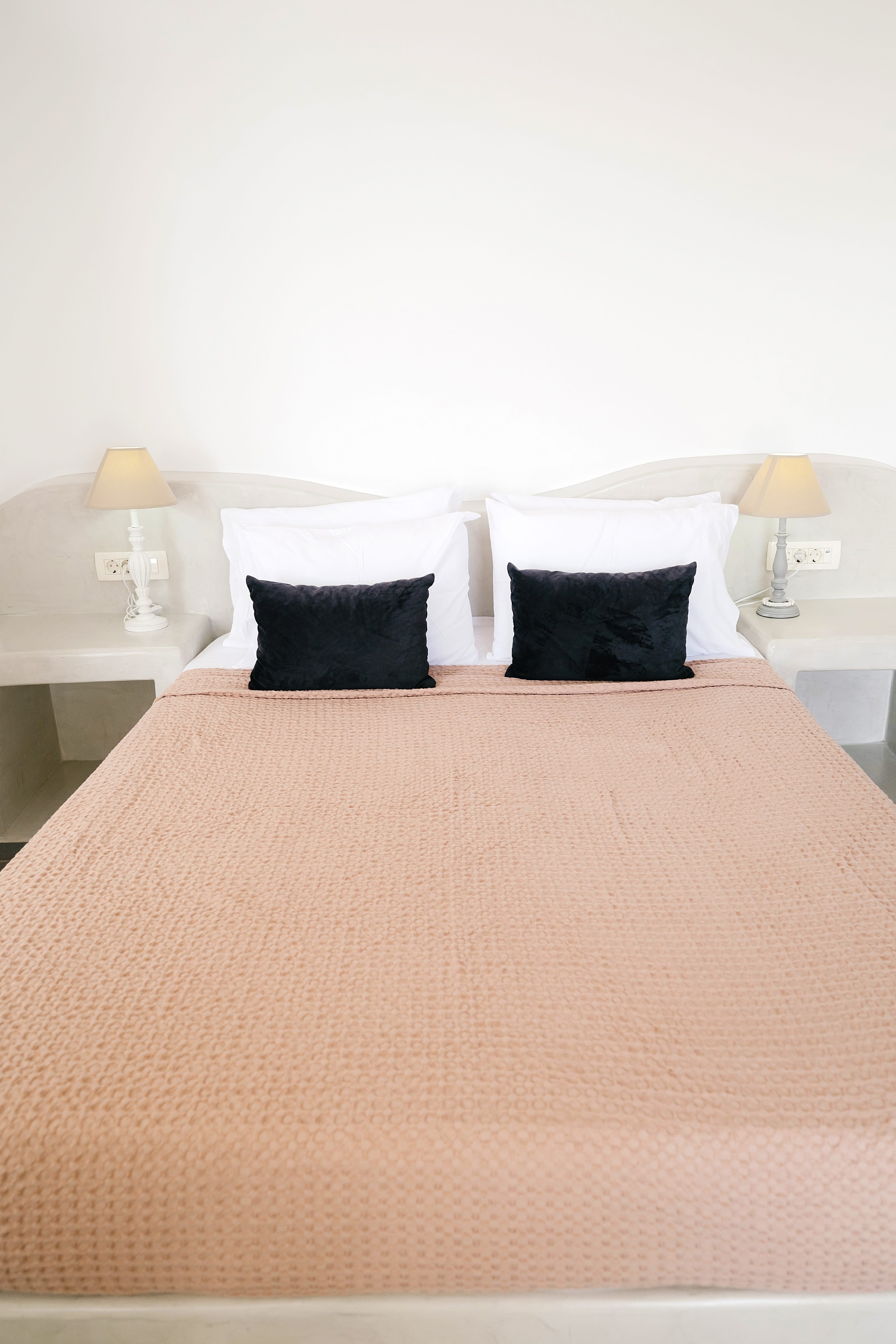 a bed with a pink comforter