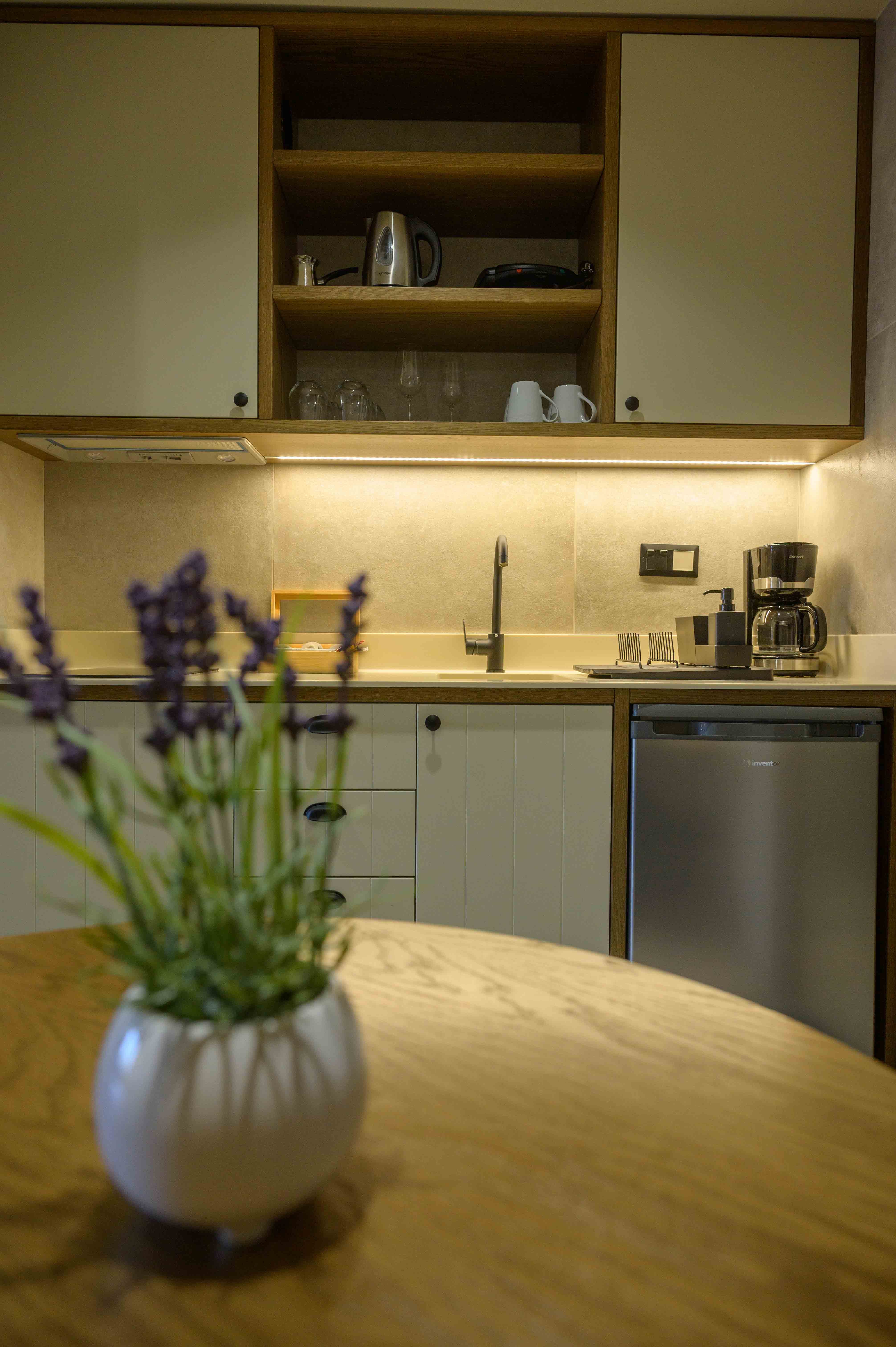 a vase with purple flowers on a kitchen counter