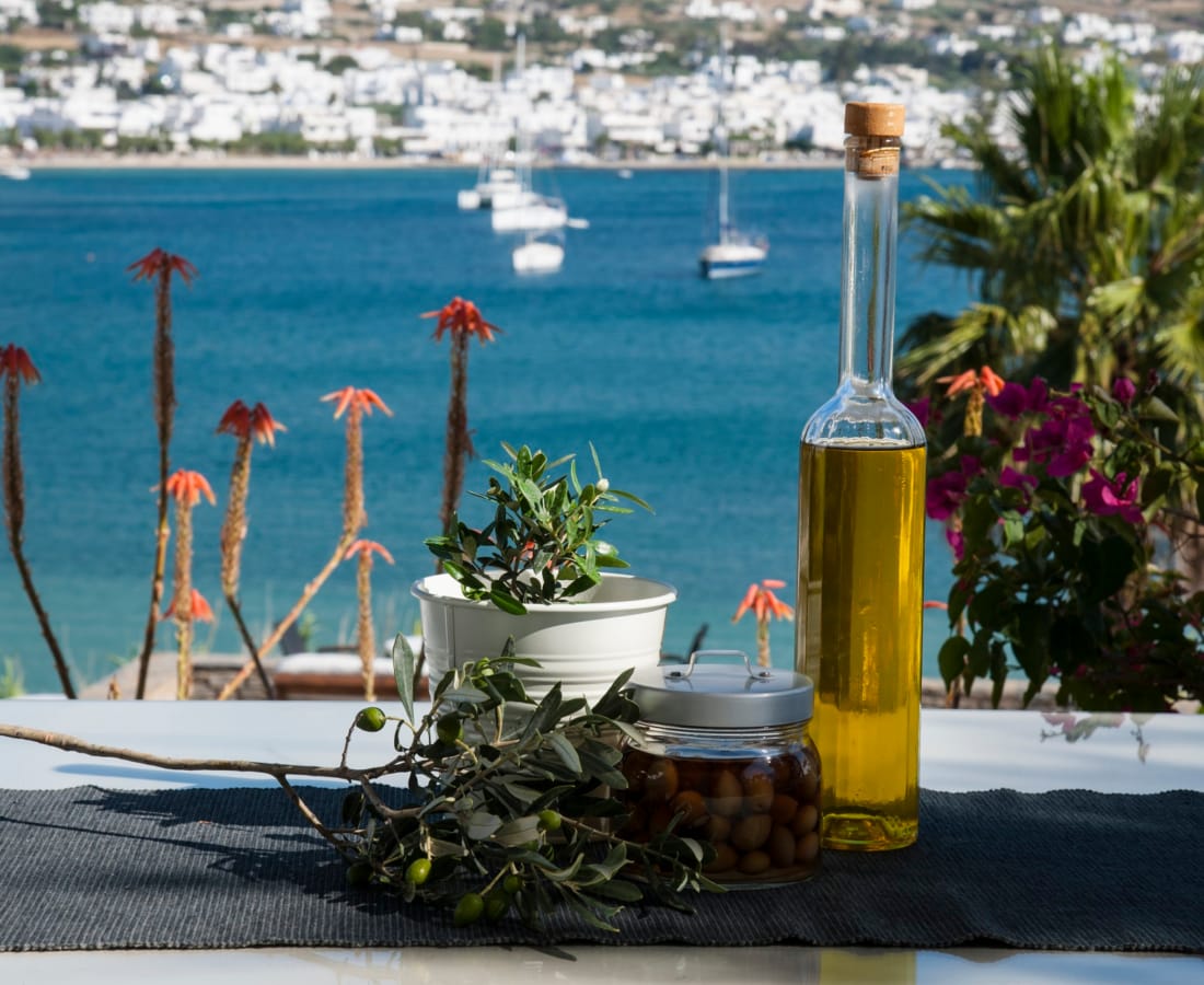 a table with a bottle and plants by a body of water