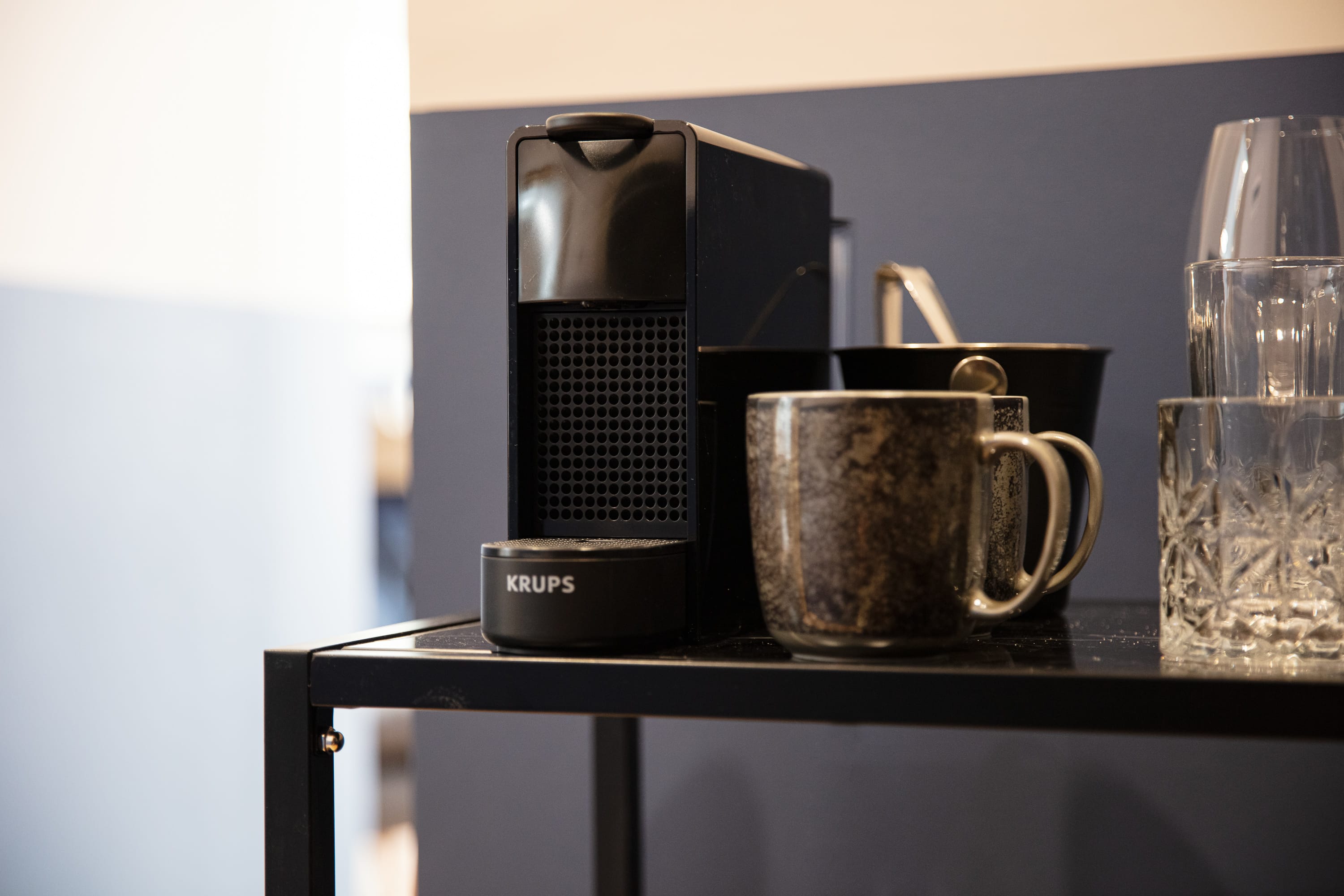 a coffee maker and a mug on a shelf