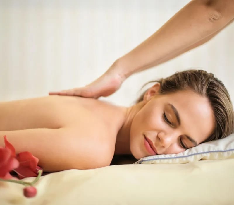 topless-woman-lying-on-bed-getting-massage-3757952