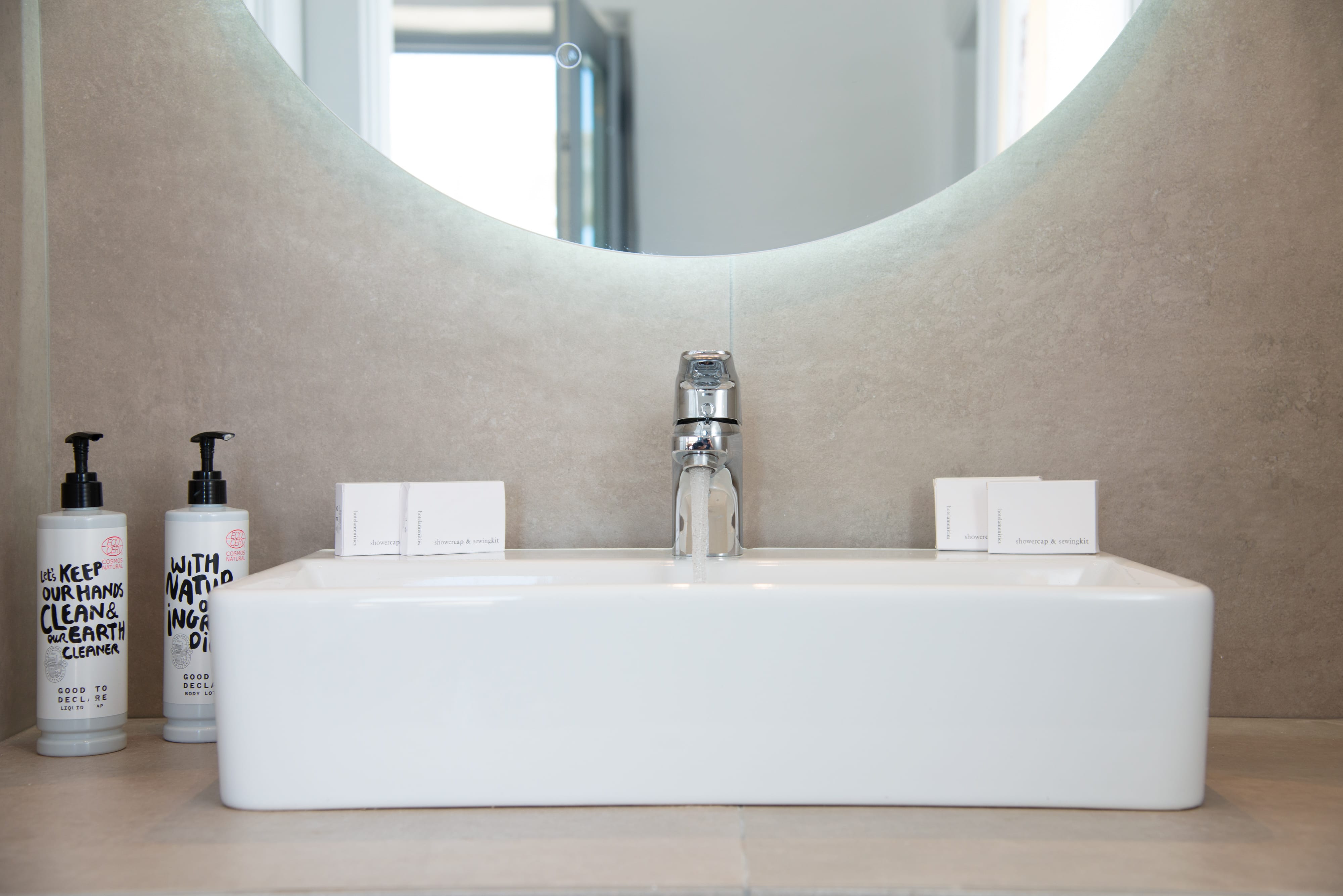 a white sink with a faucet and a white bottle
