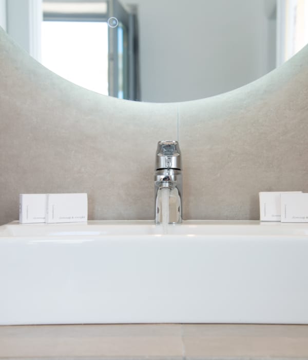 a white sink with a faucet and a white bottle