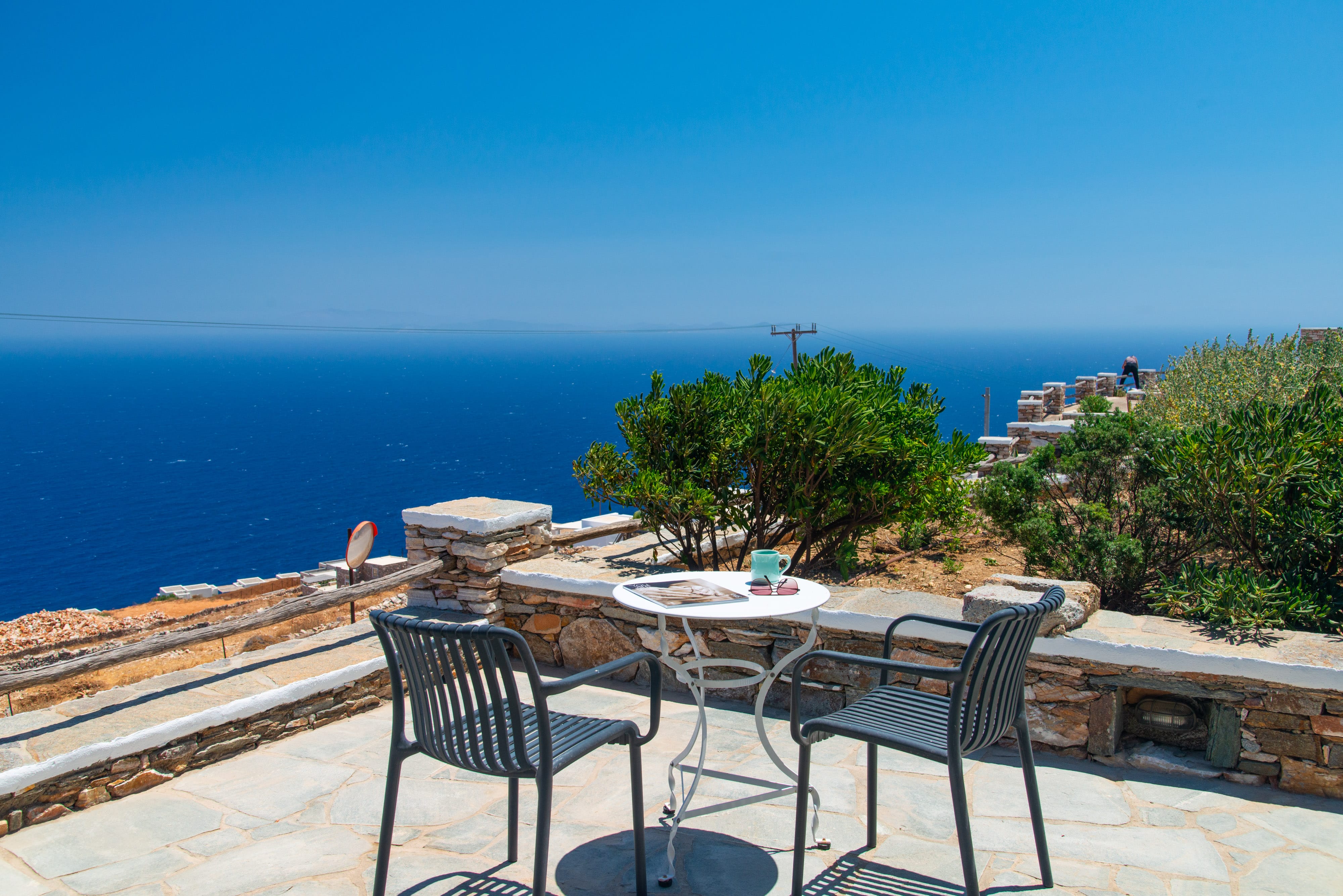 a patio with tables and chairs overlooking the ocean