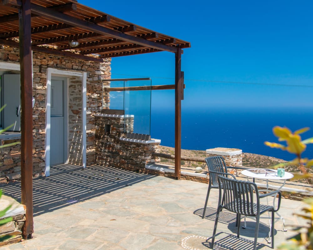 a patio with a table and chairs by a body of water