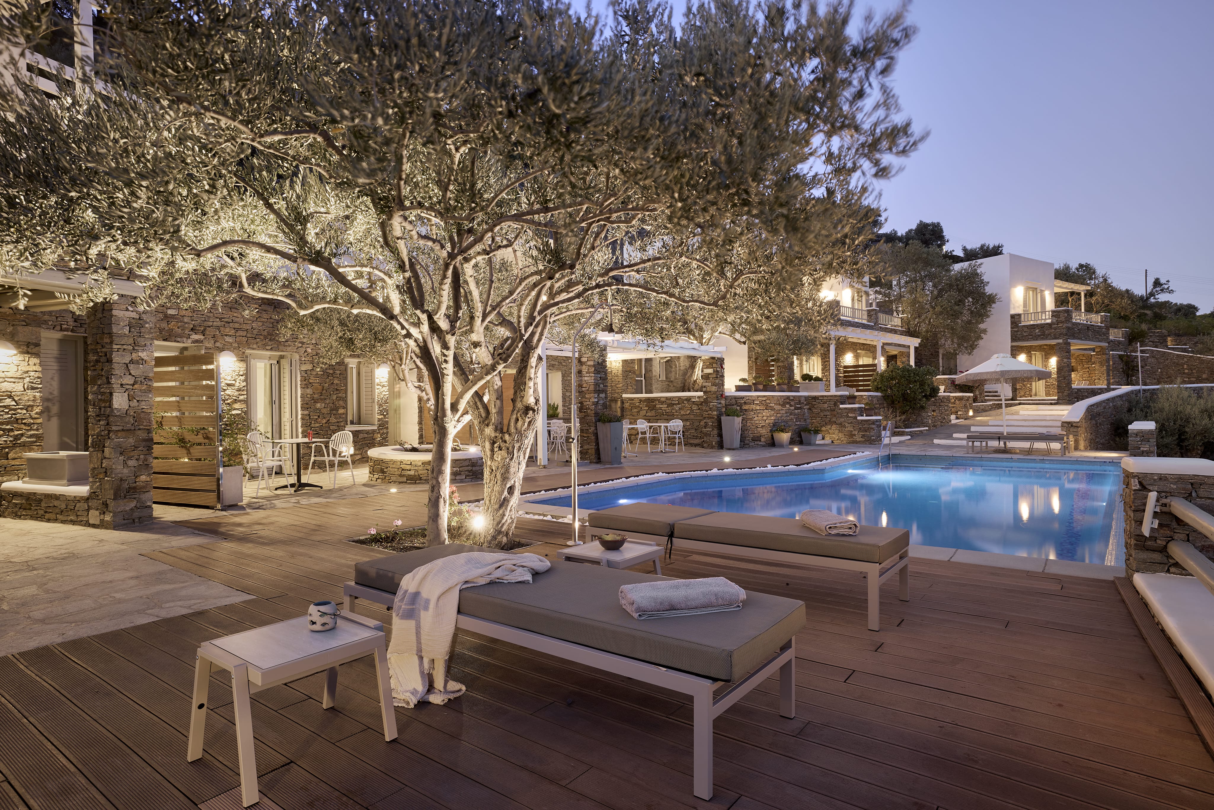 a pool with lounge chairs and a tree in the background