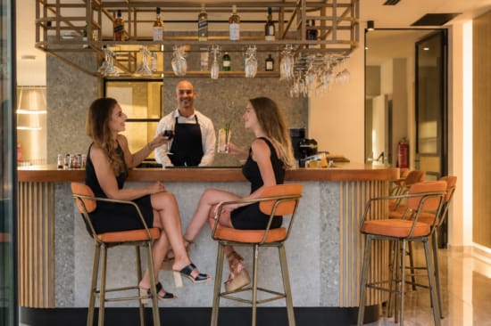 a group of women sitting at a bar