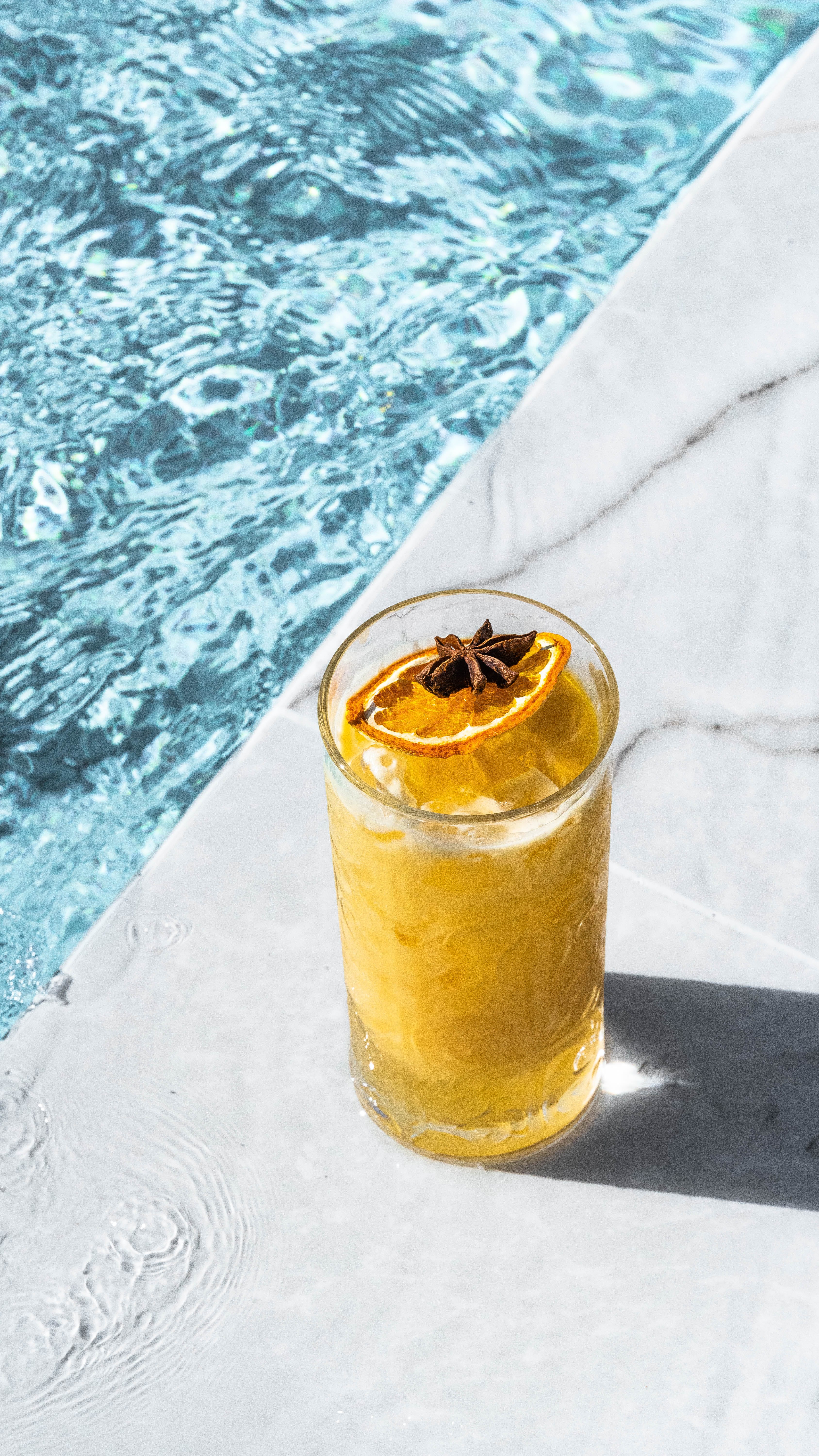 a glass of beer with a butterfly on the foam