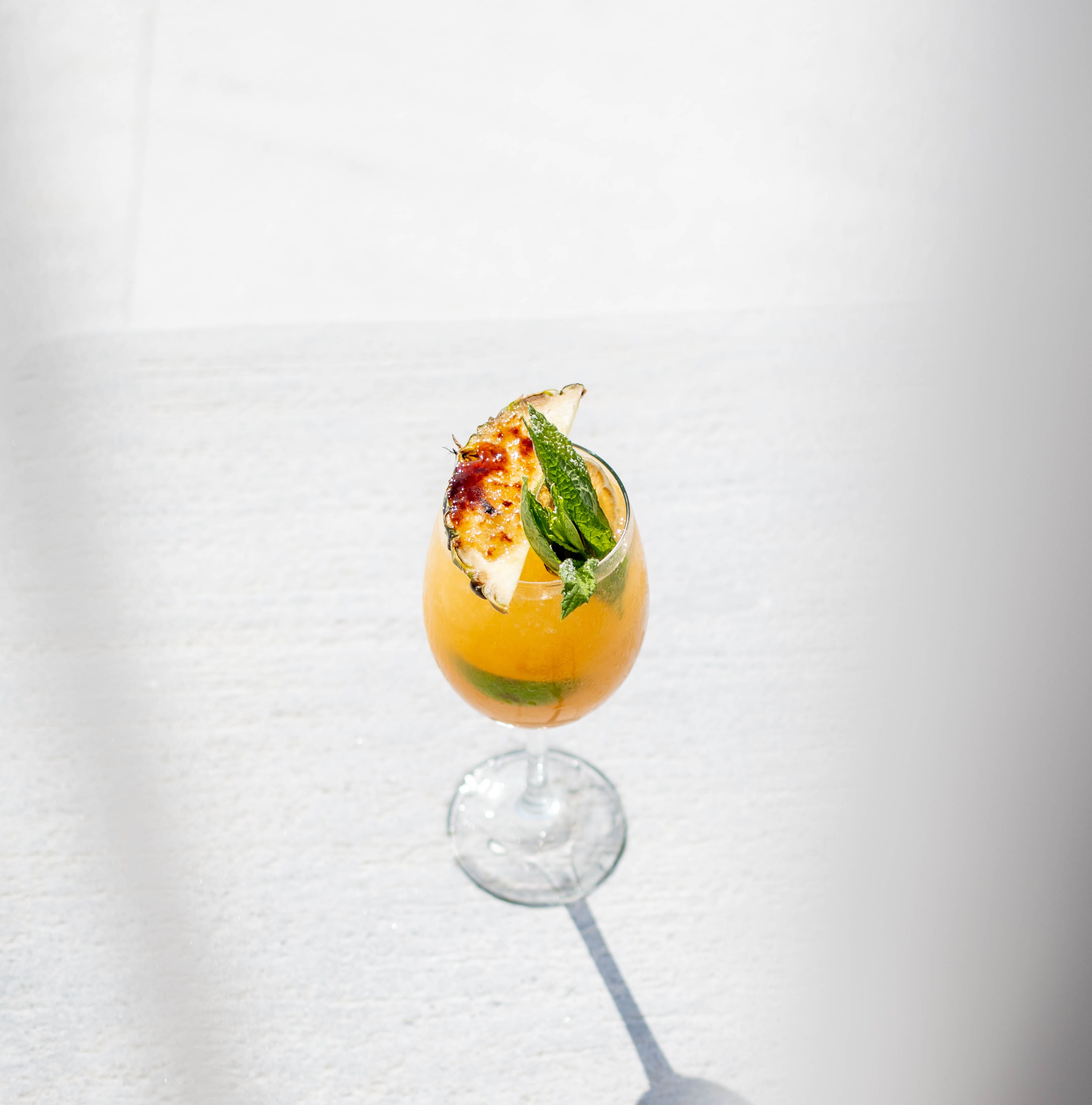 a glass of liquid with a fruit on top