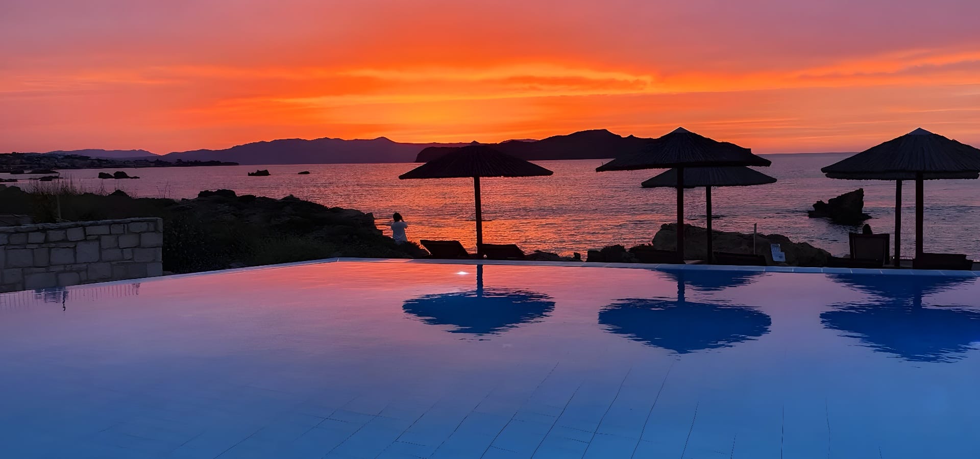 a pool with umbrellas in the foreground