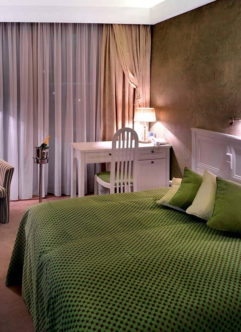 a bed with a green comforter