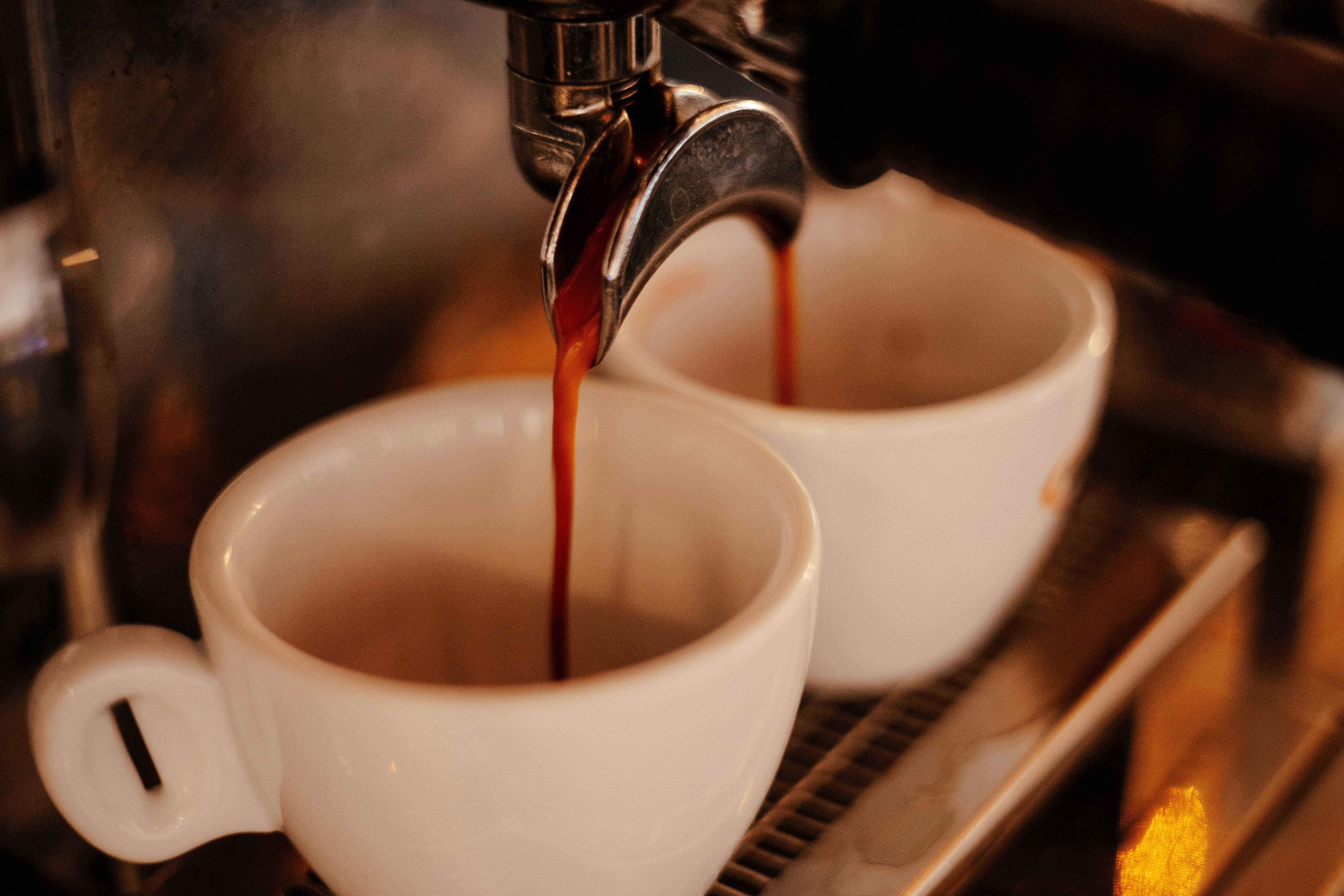 a spoon pouring liquid into a cup