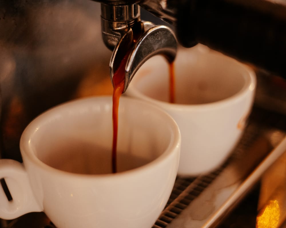 a spoon pouring liquid into a cup
