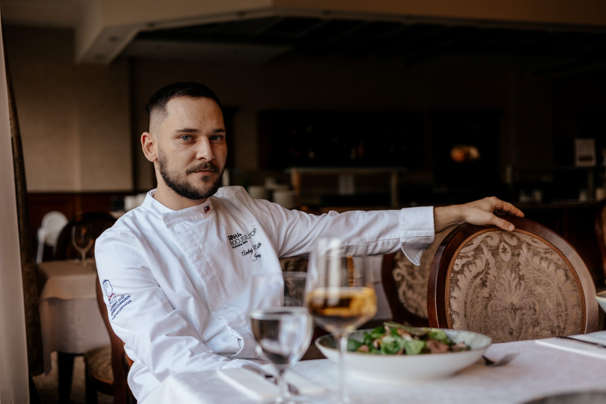 a man sitting at a table with food and drinks