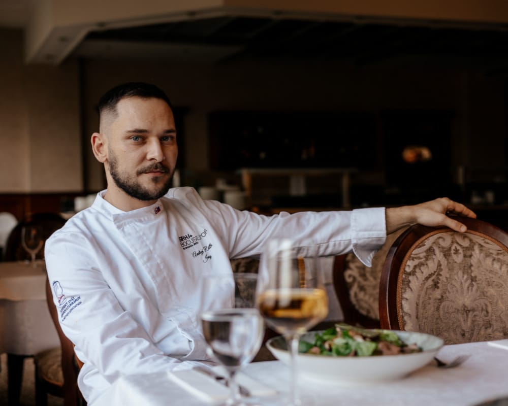 a man sitting at a table with food and drinks