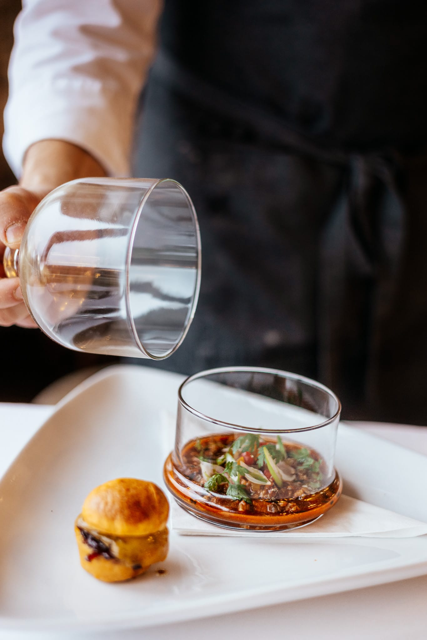 a bowl of soup next to a glass of water