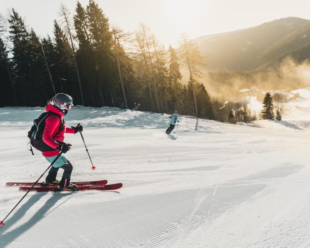 a couple of people skiing down a mountain