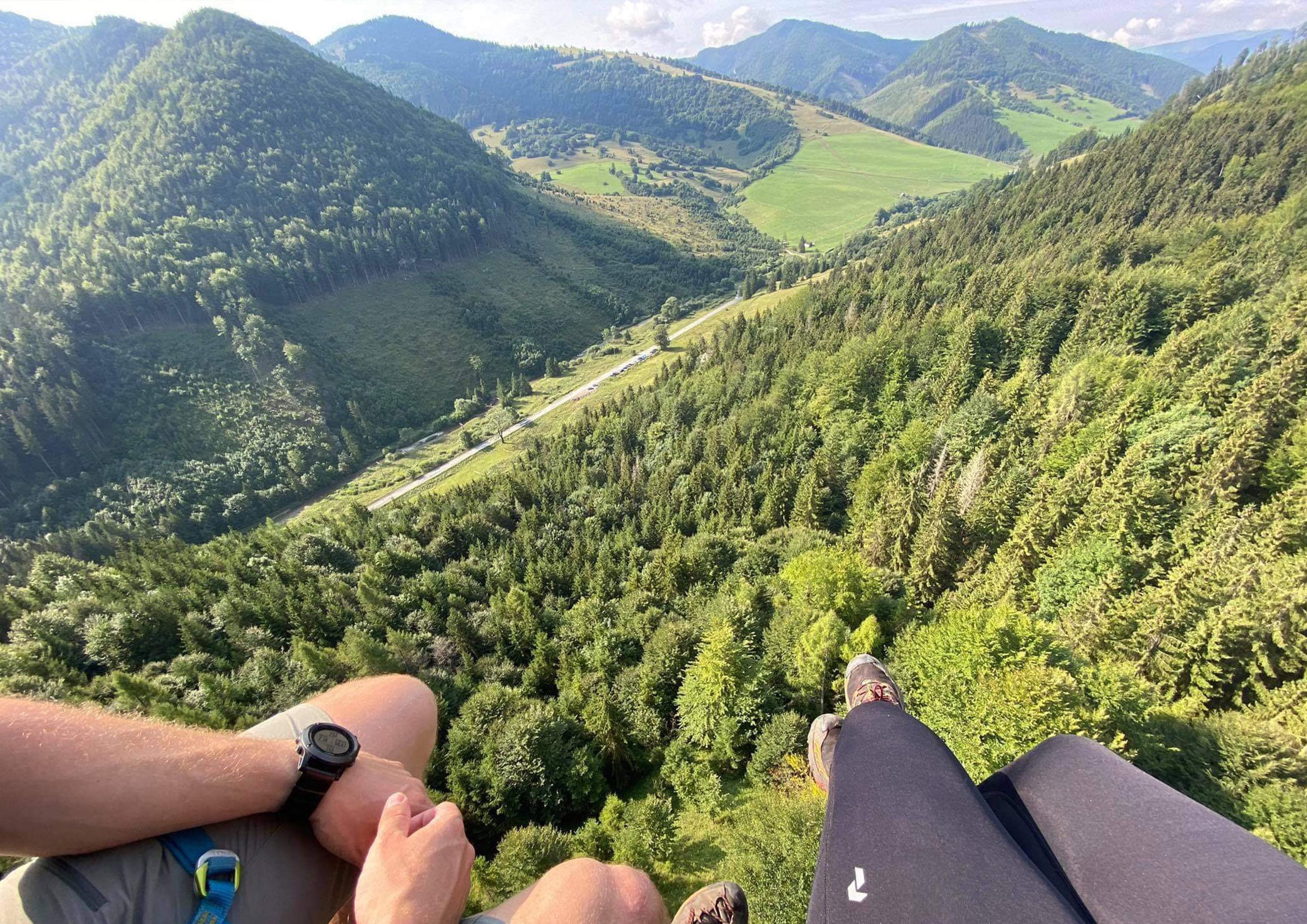 a group of people sitting on a hill overlooking a valley