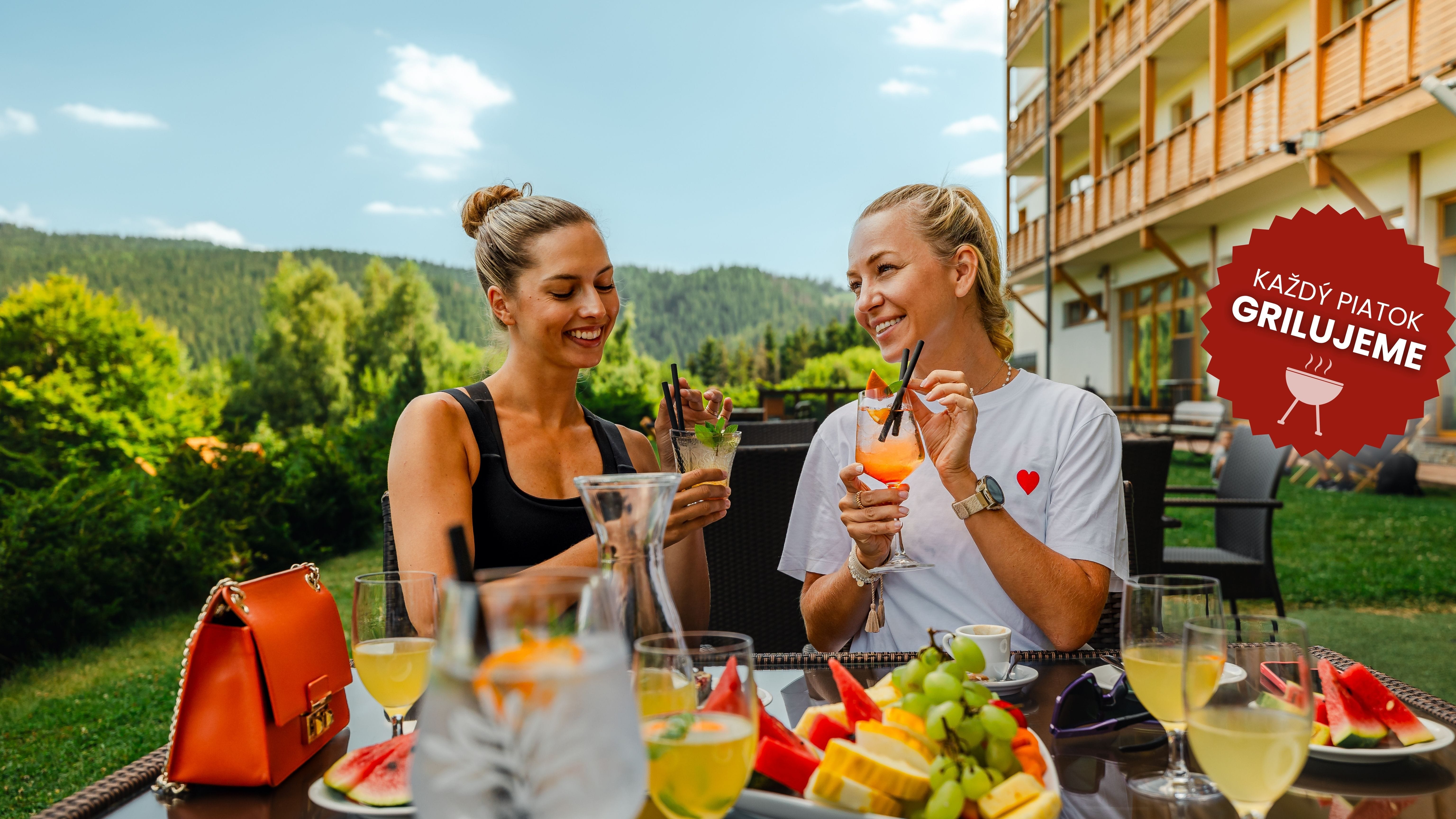 a man and woman sitting at a table with food and drinks