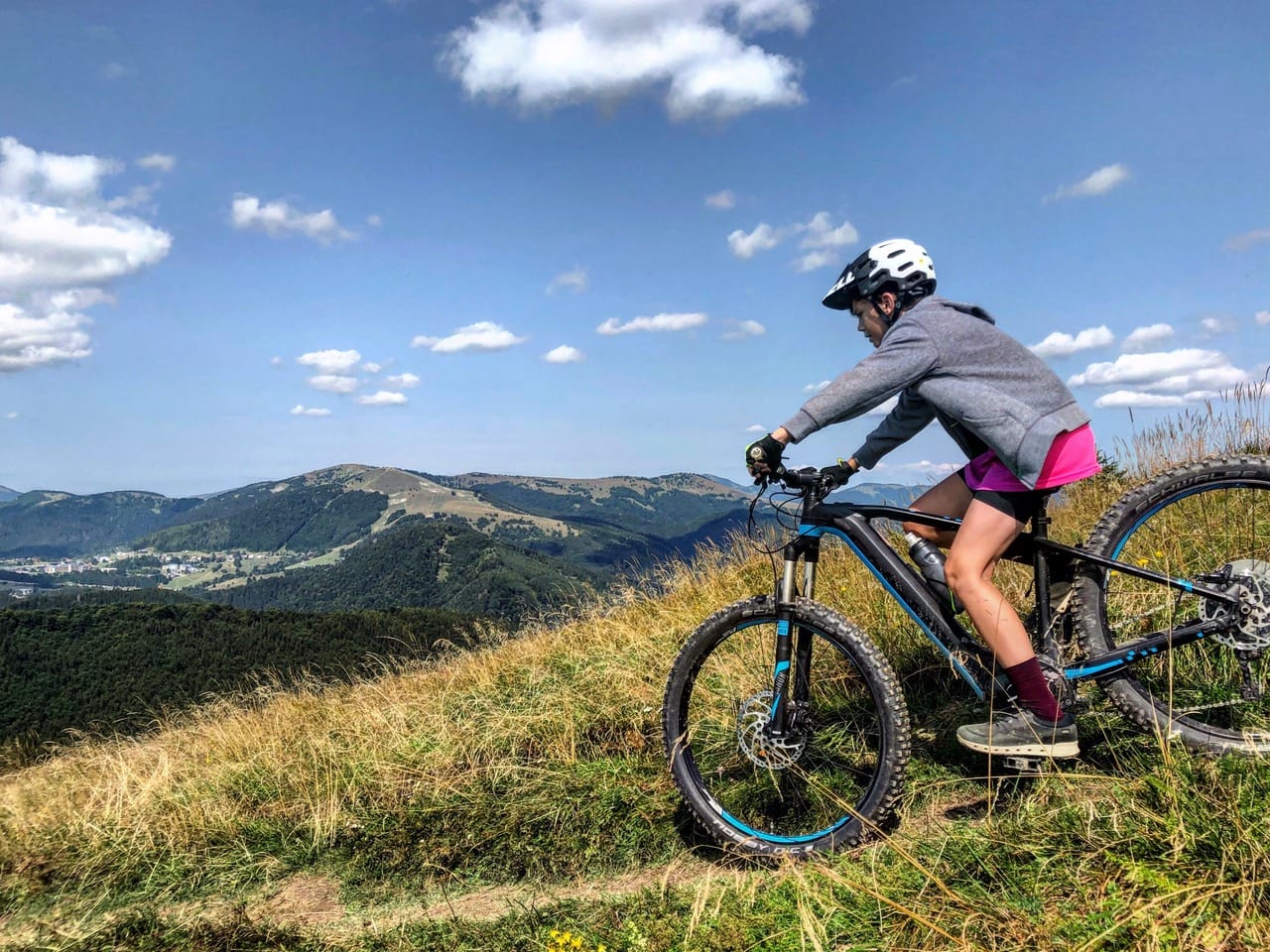 a person riding a bike on a grassy hill