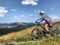 a person riding a bike on a grassy hill