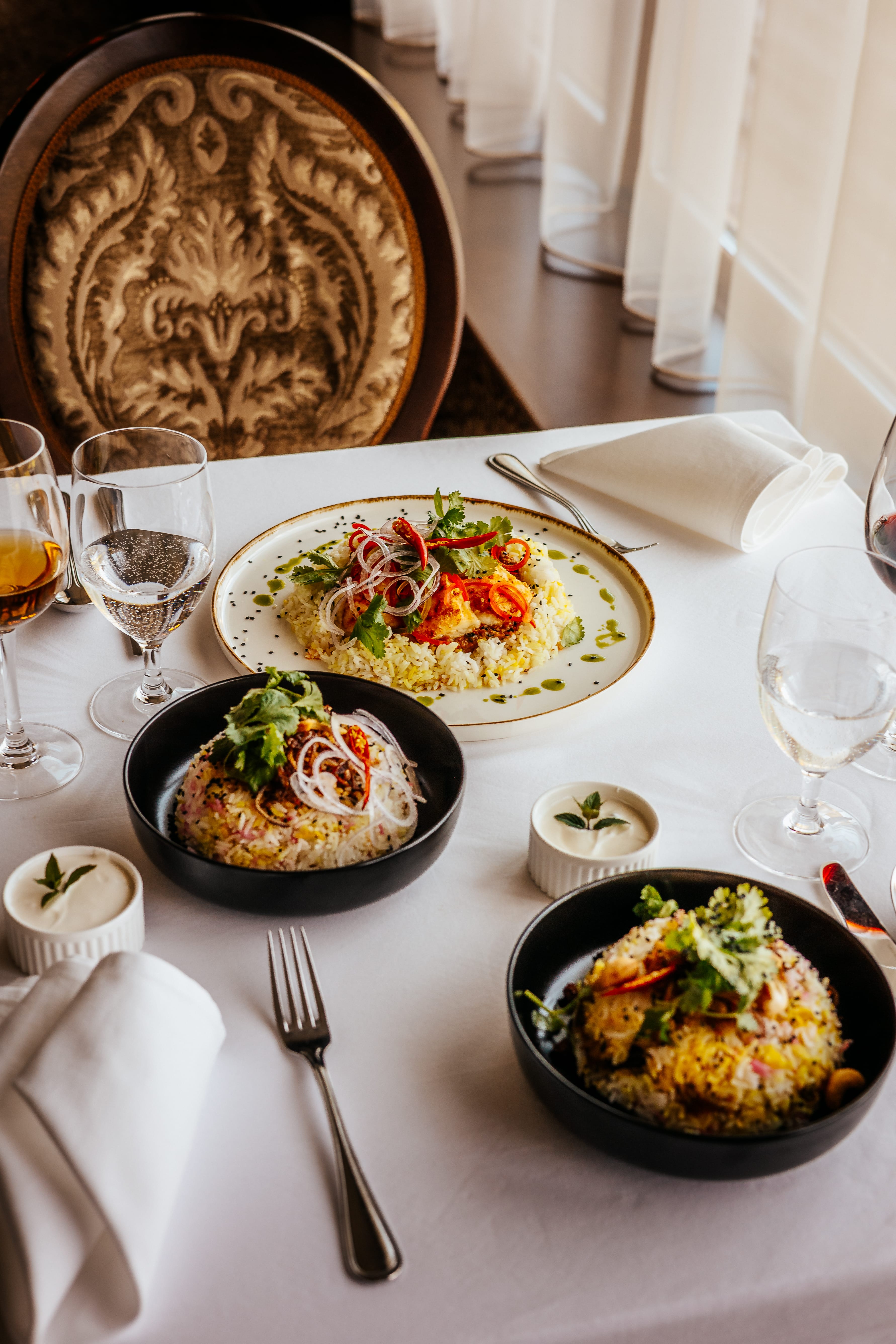 a table with plates of food and glasses of wine