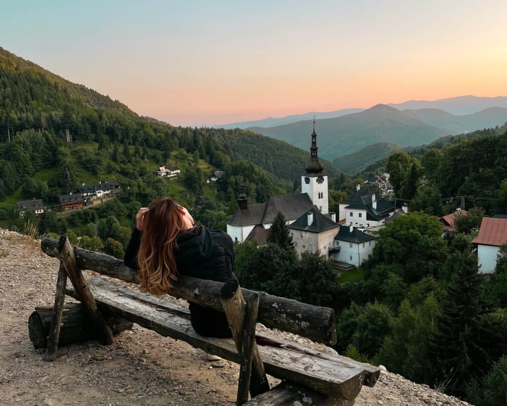 a person sitting on a bench overlooking a town