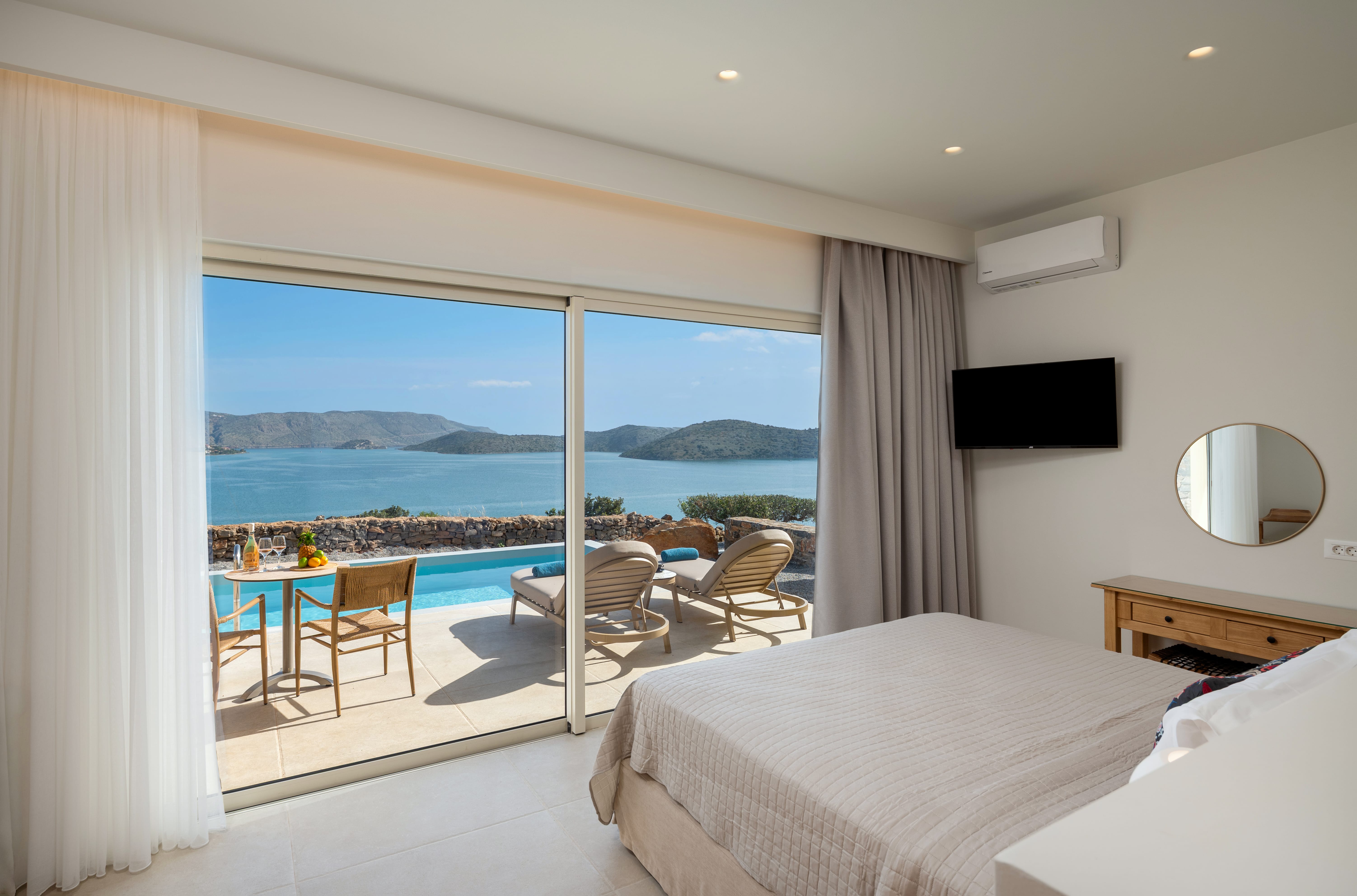 a bedroom with a view of the ocean and a table