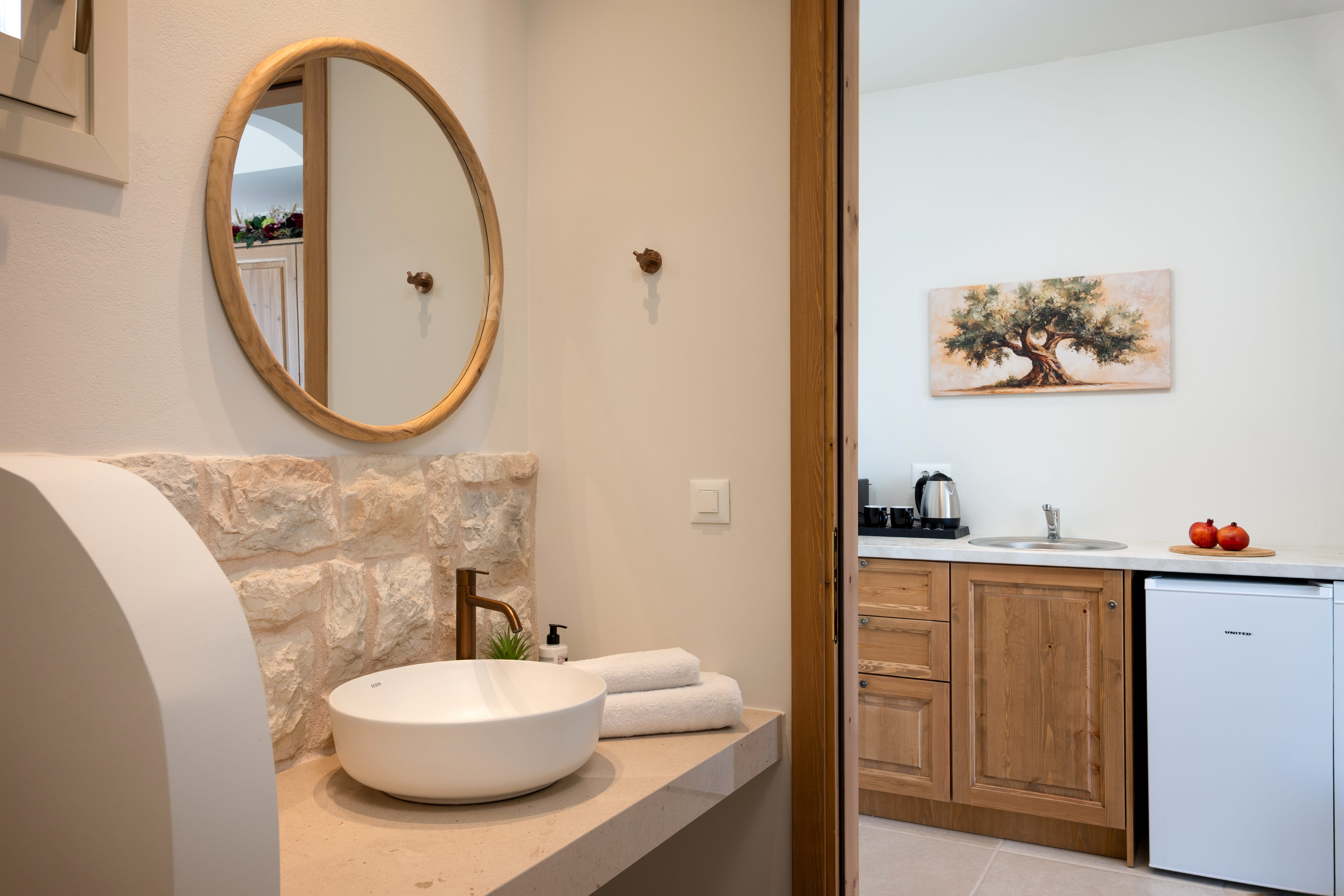 a bathroom with a round mirror and sink