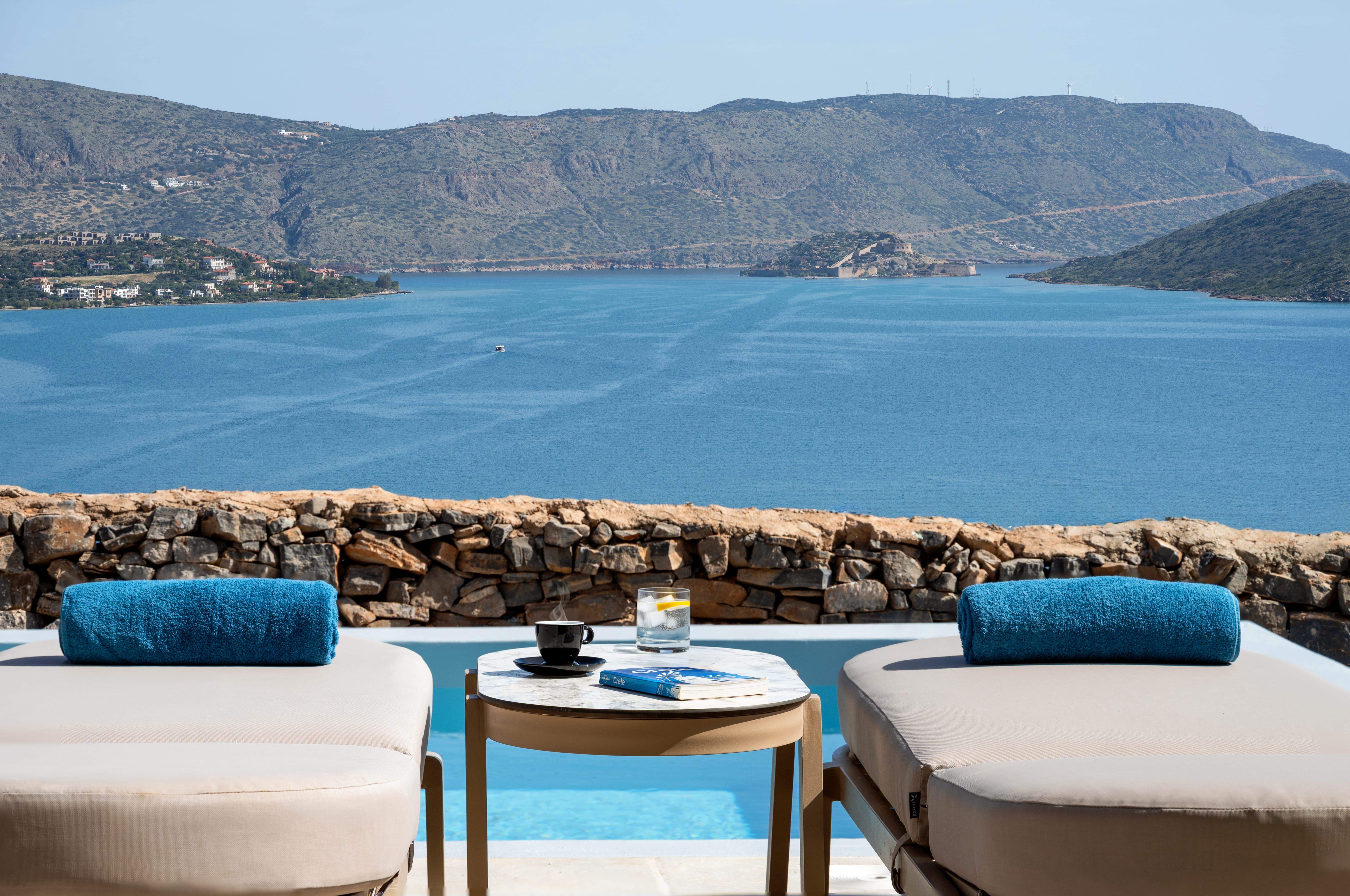 a table and chairs with a view of the ocean