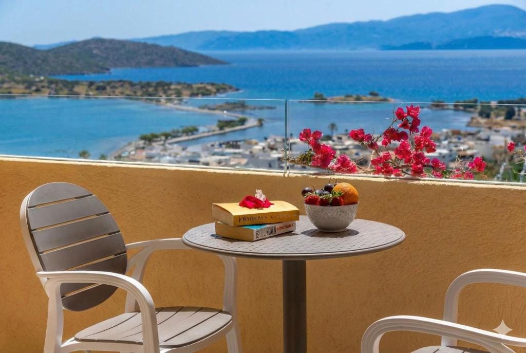 a table and chairs on a balcony overlooking a body of water