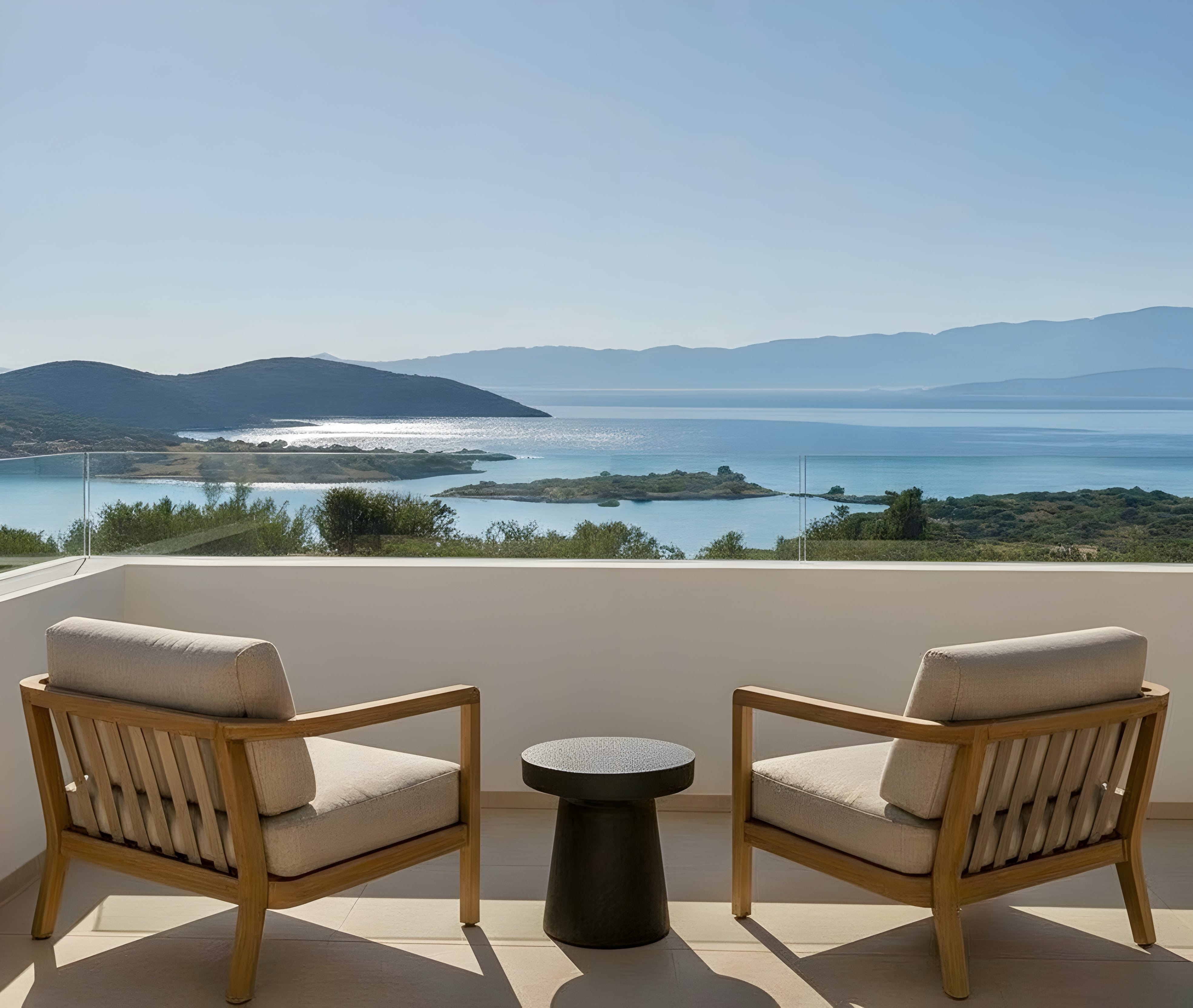 a couple of chairs on a balcony overlooking a body of water