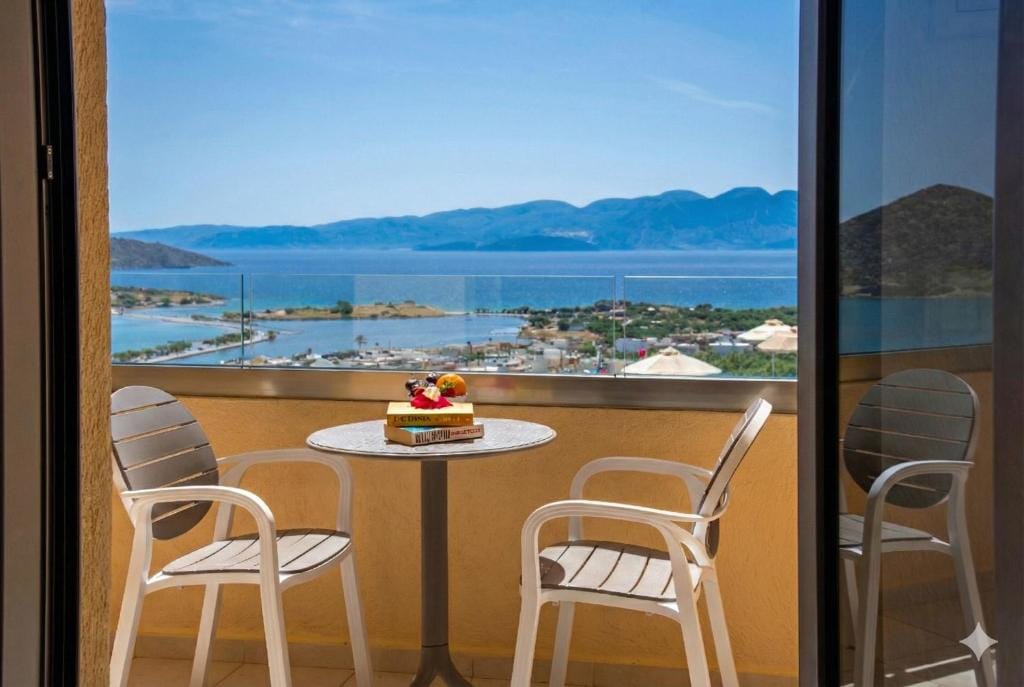 a table and chairs on a balcony overlooking a body of water