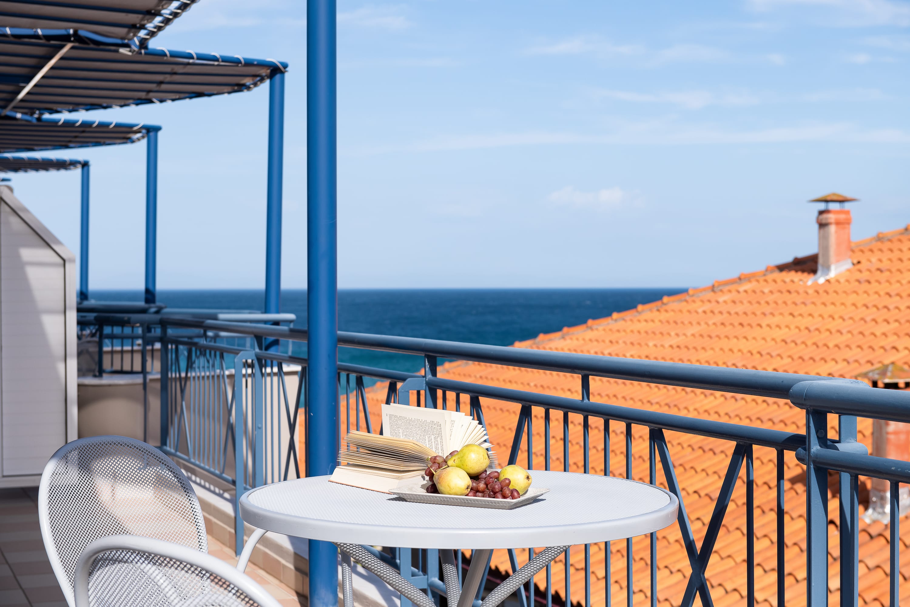 a table with food on it on a balcony overlooking the ocean