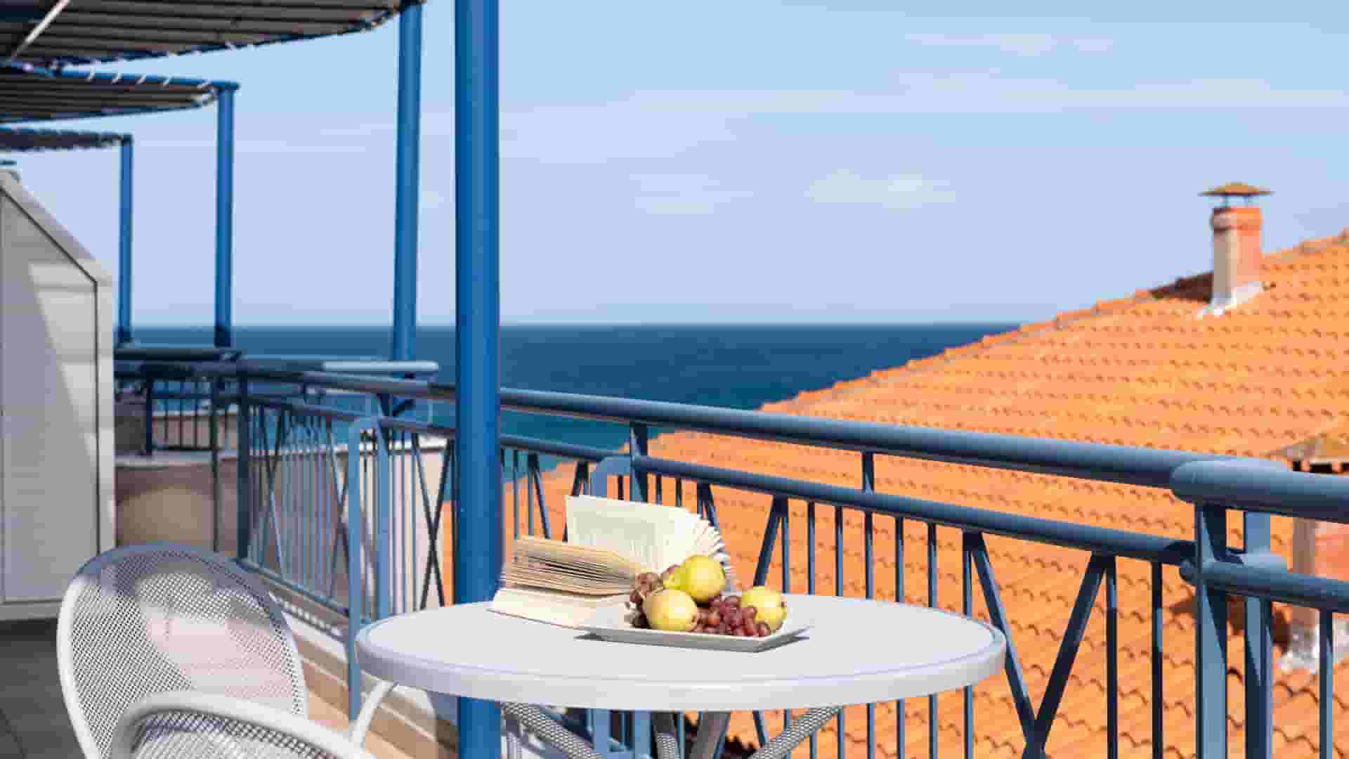 a table with food on it on a balcony overlooking the ocean