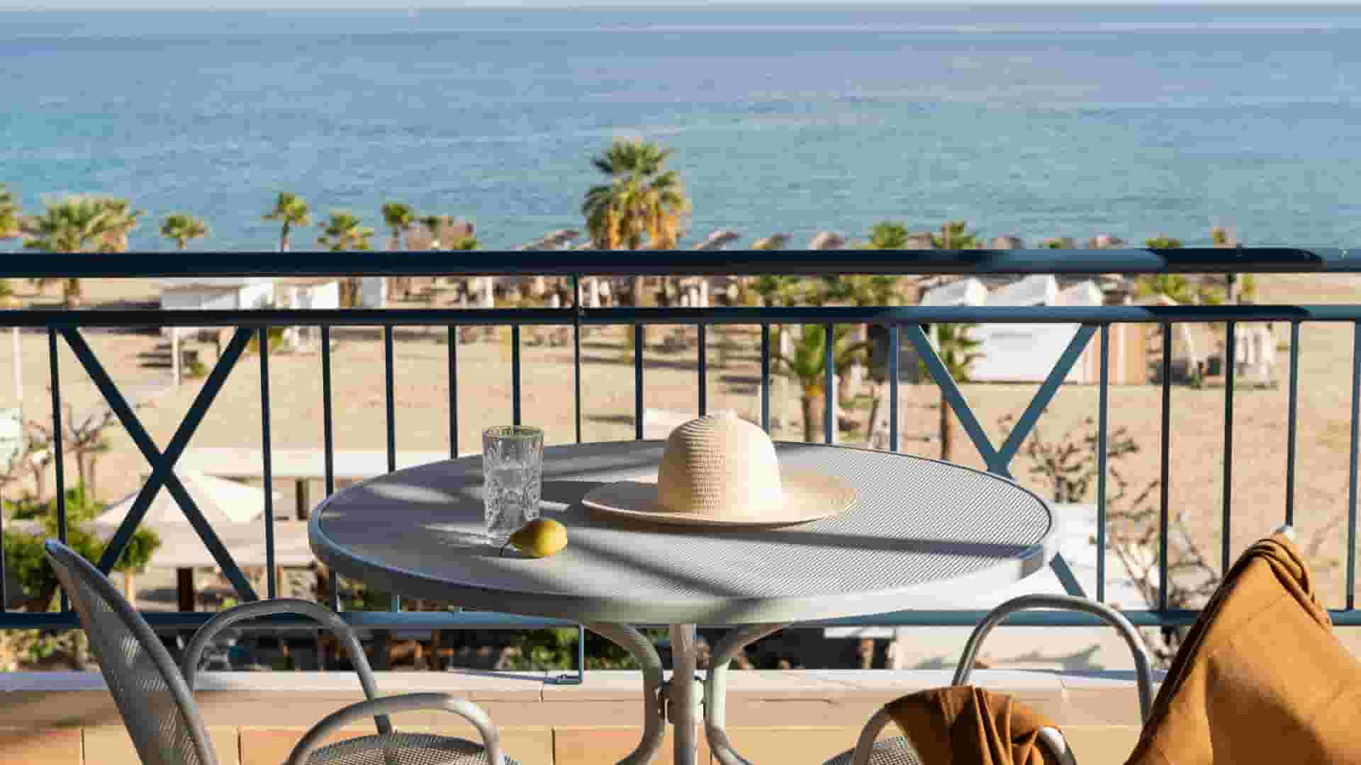 a table with a hat and chairs by a body of water