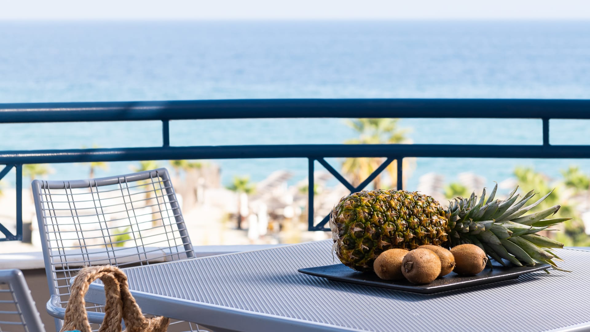 a table with a basket of fruit on it by a body of water